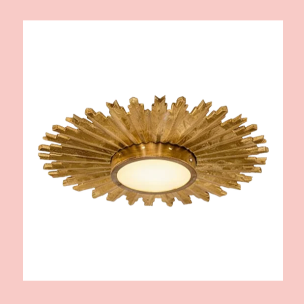 Gold and white decorative ceiling light fixture with sunburst design.