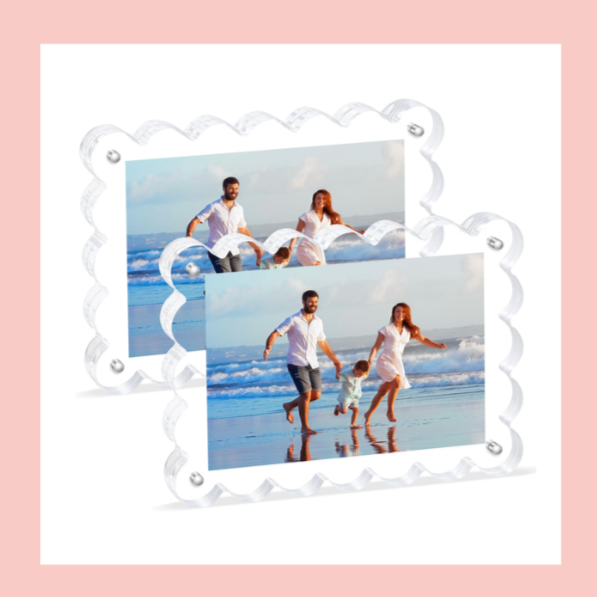 Two framed photos of a family playing on the beach, with one adult man and woman, and a child, all smiling and holding hands in the shallow water.