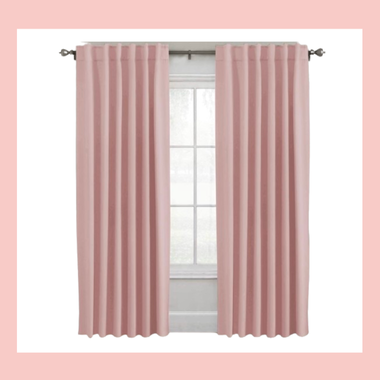 Pink curtains hanging in front of a window with frosted glass, on a wall with a pink border.