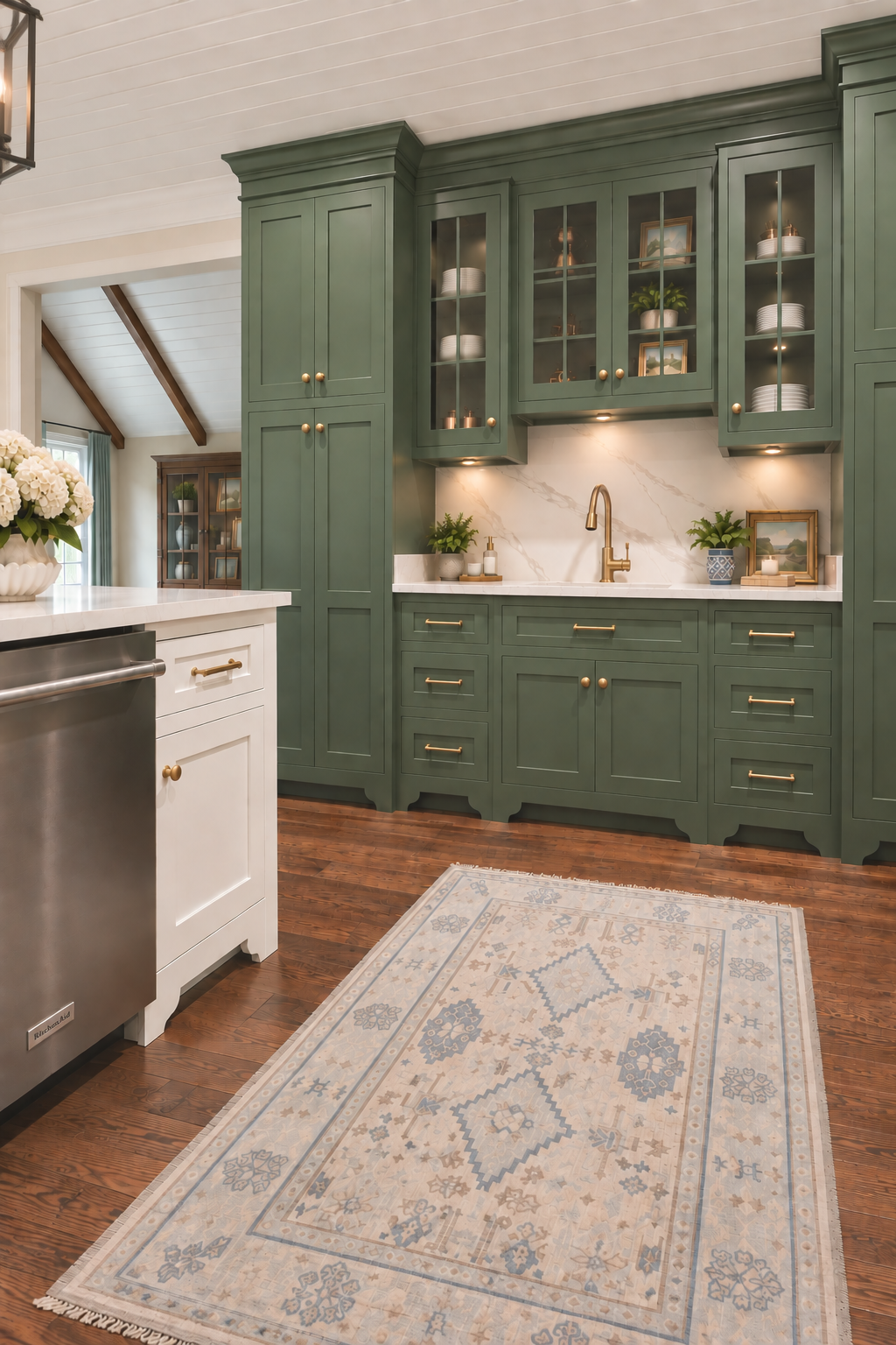 A collected kitchen where classic details meet fresh color. Custom sage-green cabinetry, warm brass accents, natural wood tones, and soft blue textiles create a space that feels timeless, inviting, and distinctly Southern. Thoughtful layers and tailo