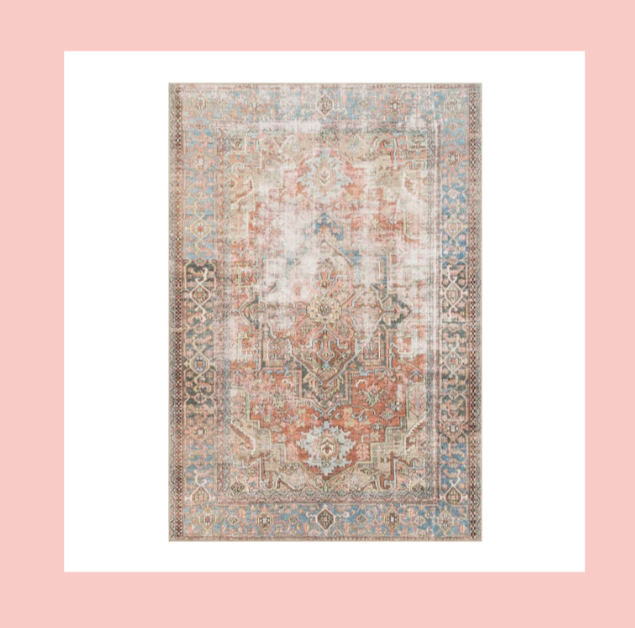 Vintage patterned area rug with floral and geometric designs in faded shades of red, blue, and beige.