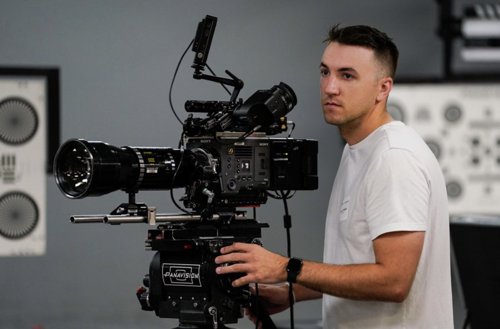 Man operating a professional video camera in a studio setting.