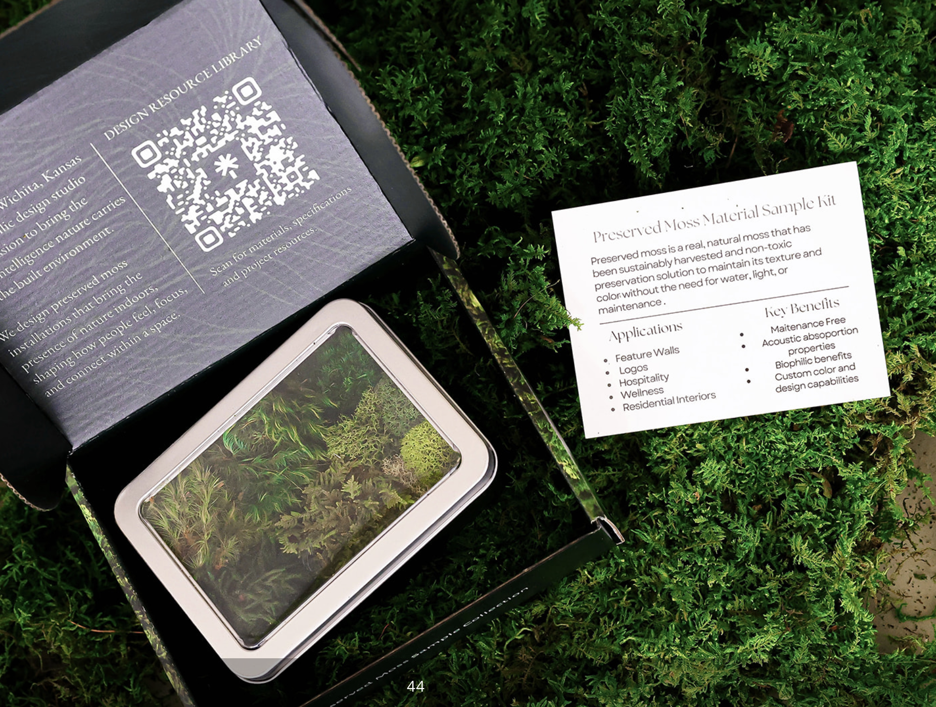 Close-up of preserved moss material sample kit with informational sheet, QR code, and a container with live moss plants, all placed on green moss ground.