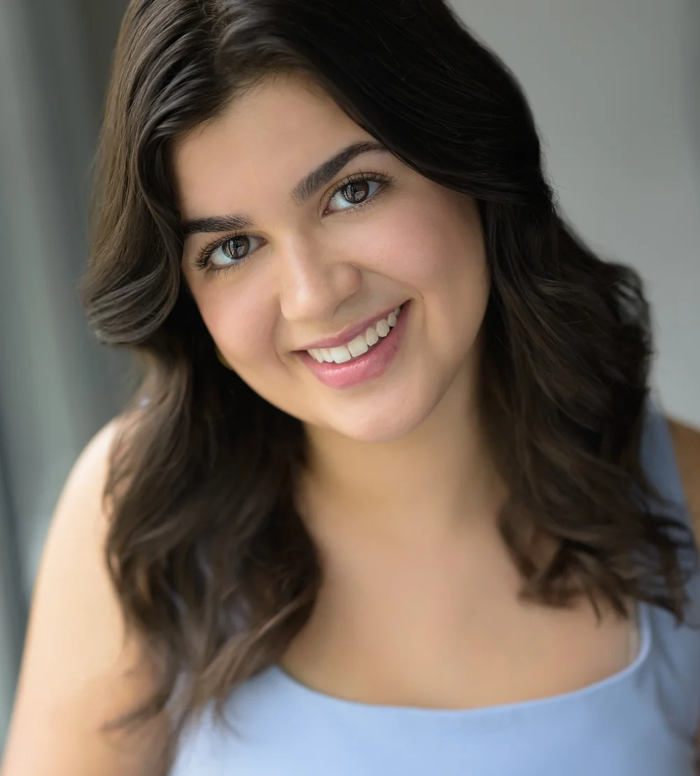 Gabrielle Vecciarelli smiling in a blue top. Headshot by Matt Simpkins.