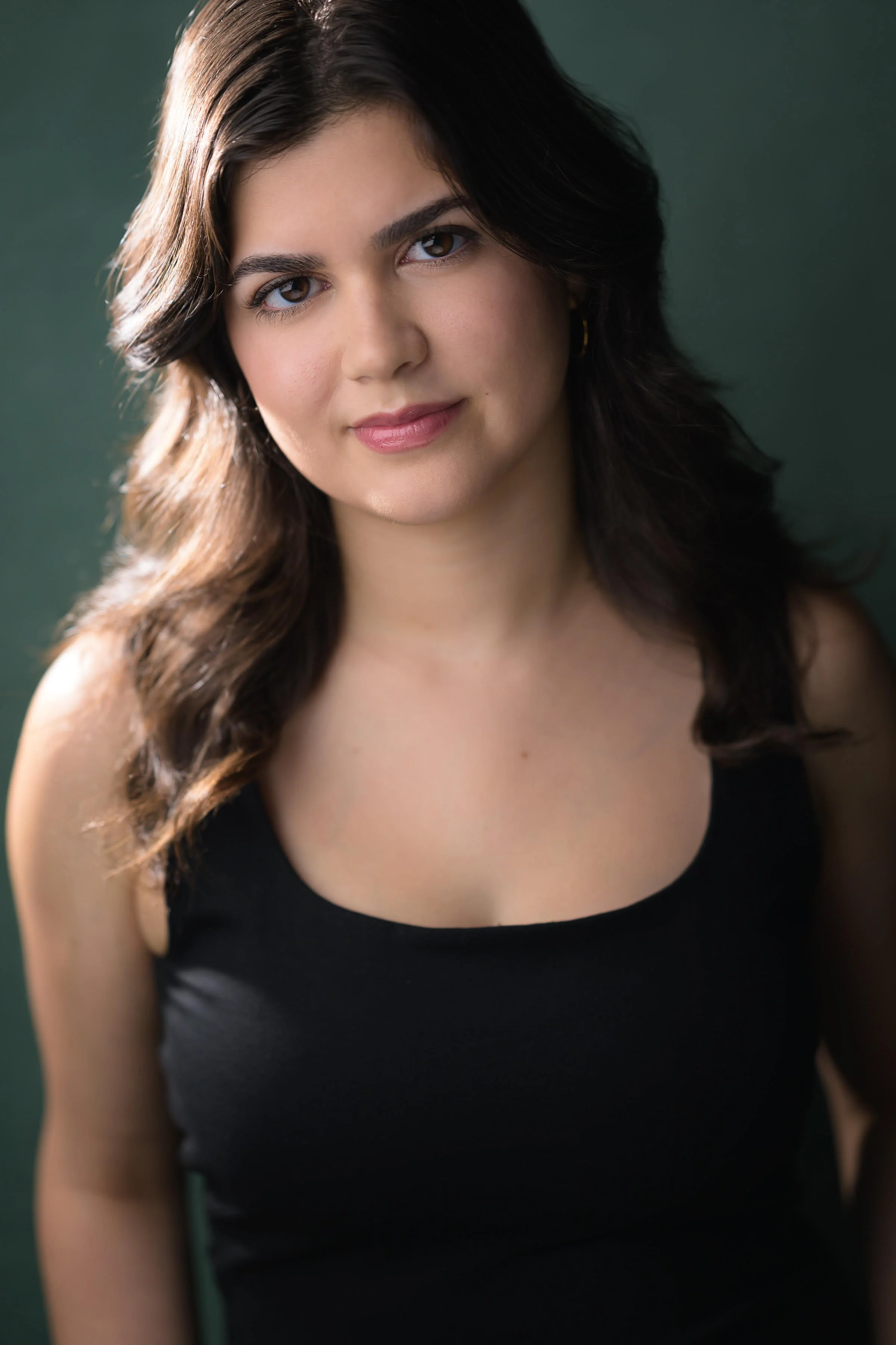 Gabrielle Vecciarelli, actor, wearing a black top against a green background.