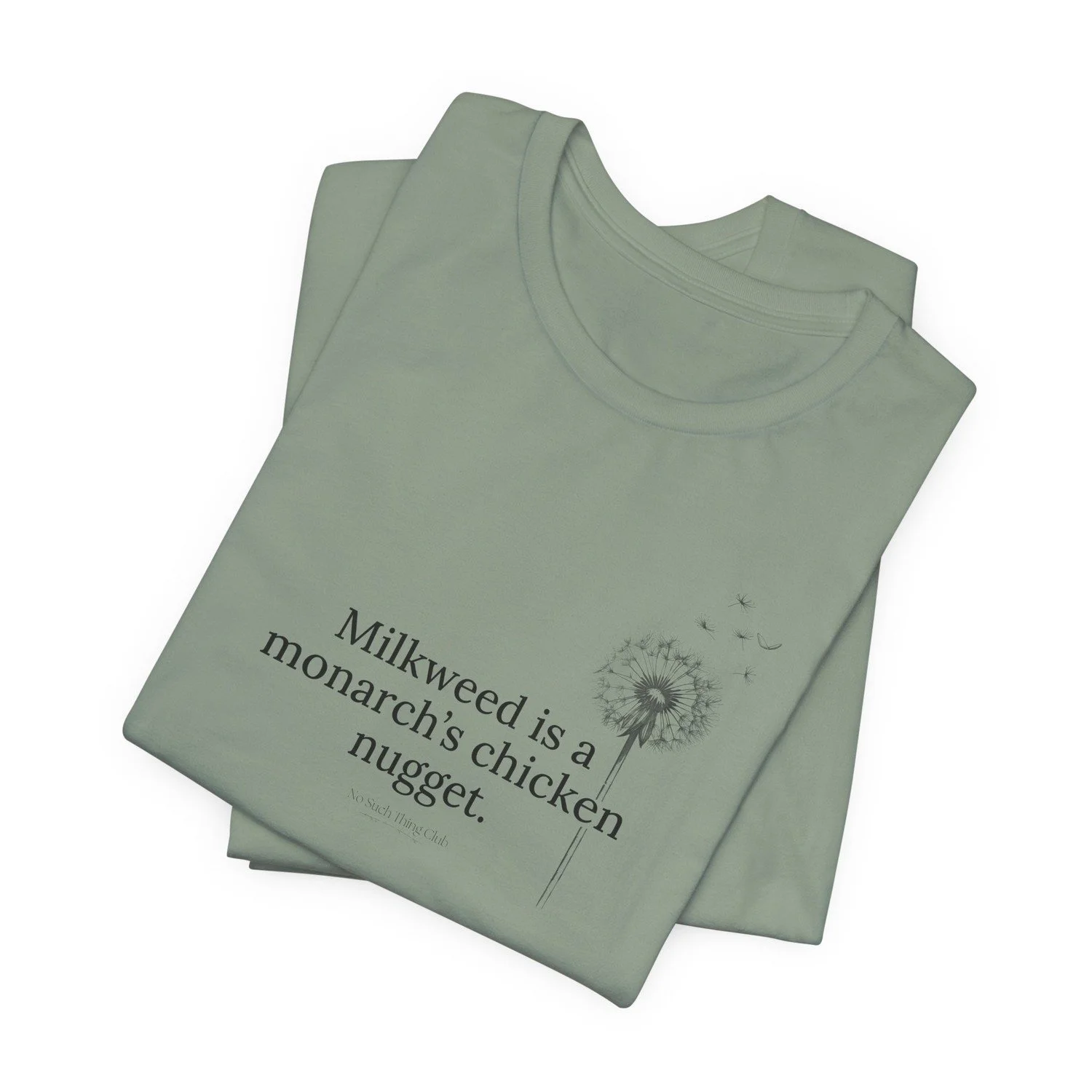 The chicken nugget tee in Heather Sage, folded, with the dandelion and No Such Thing Club under the words