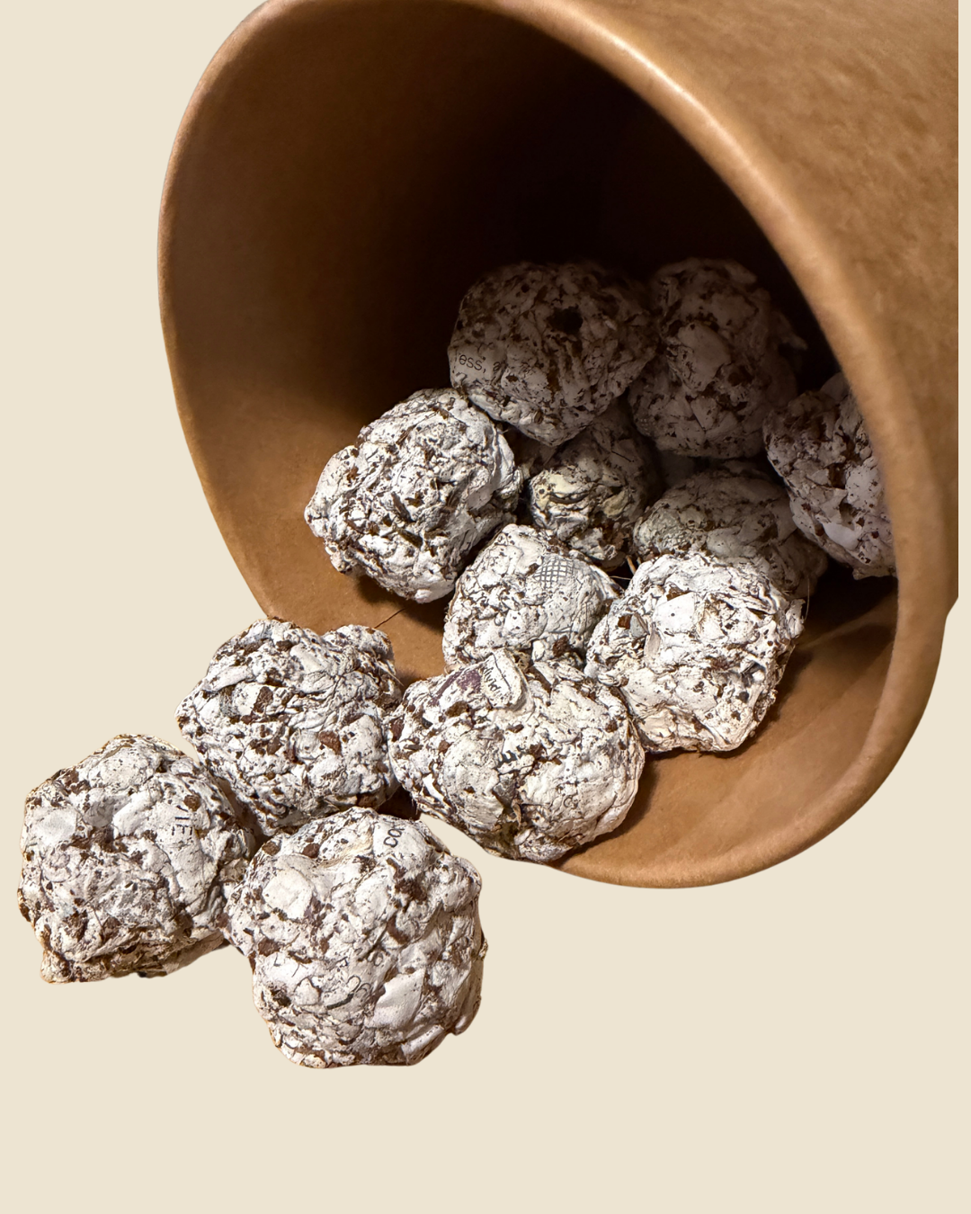Seed balls spilling from a tipped wooden cup