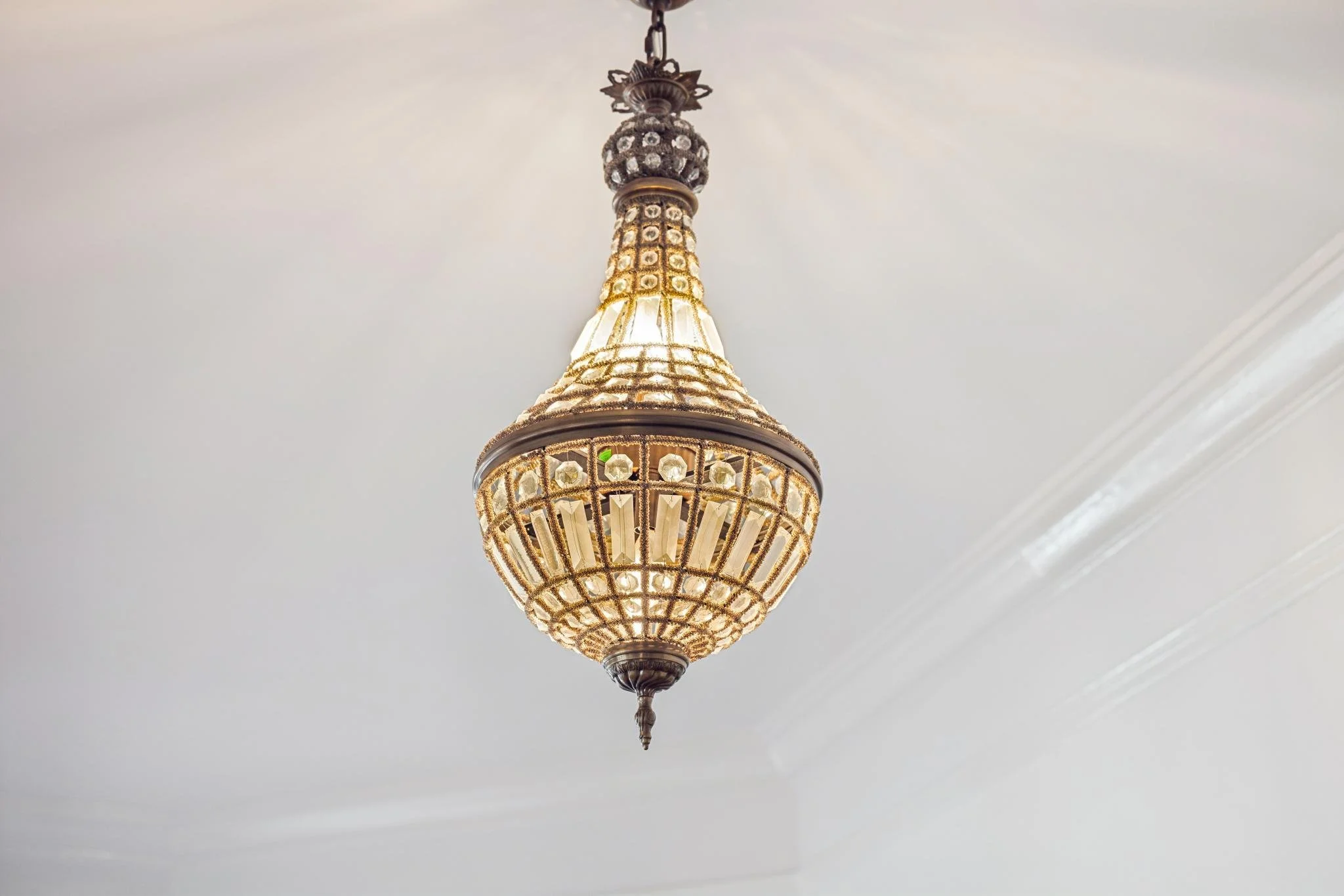 An ornate chandelier hanging from a white ceiling.