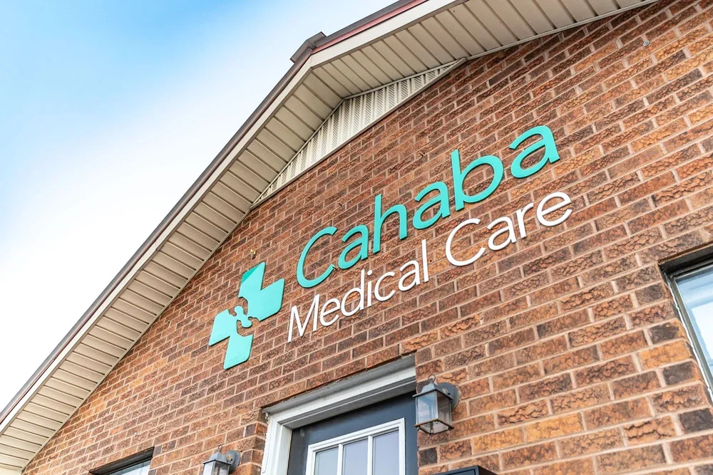 Exterior view of Cahaba Medical Care building with brick facade, logo, and signage.
