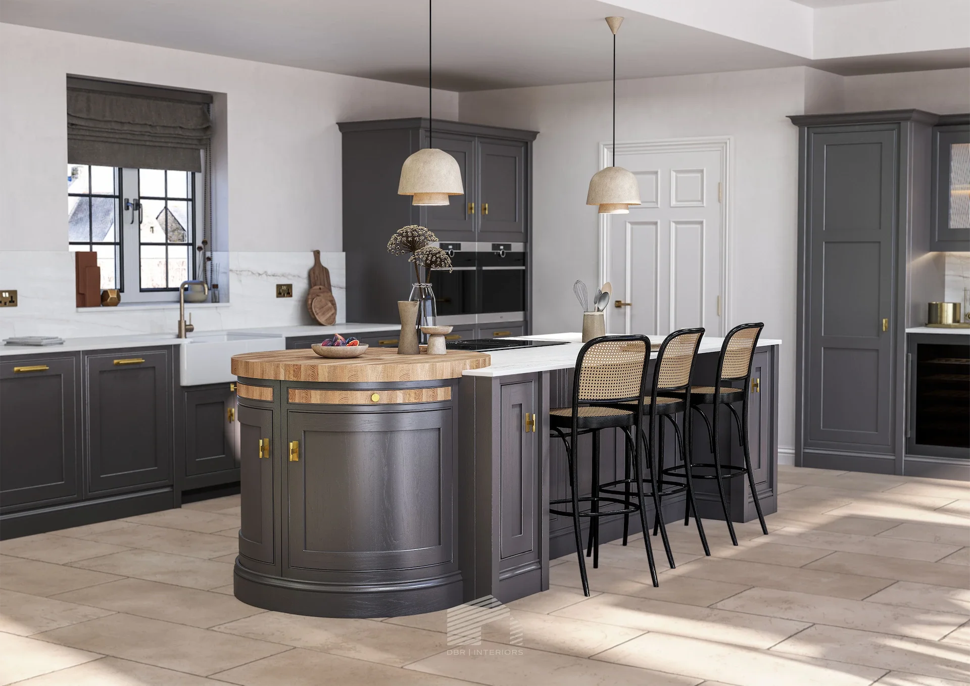 Modern kitchen with gray cabinets, white countertops, and a center island with a rounded side. The island has a wooden top extension. Four black chairs with woven seats are positioned along the island. Pendant lights hang above. There is a window with a gray Roman shade above a white farmhouse sink. Various utensils, vases, and decorations are on the countertops and shelves.