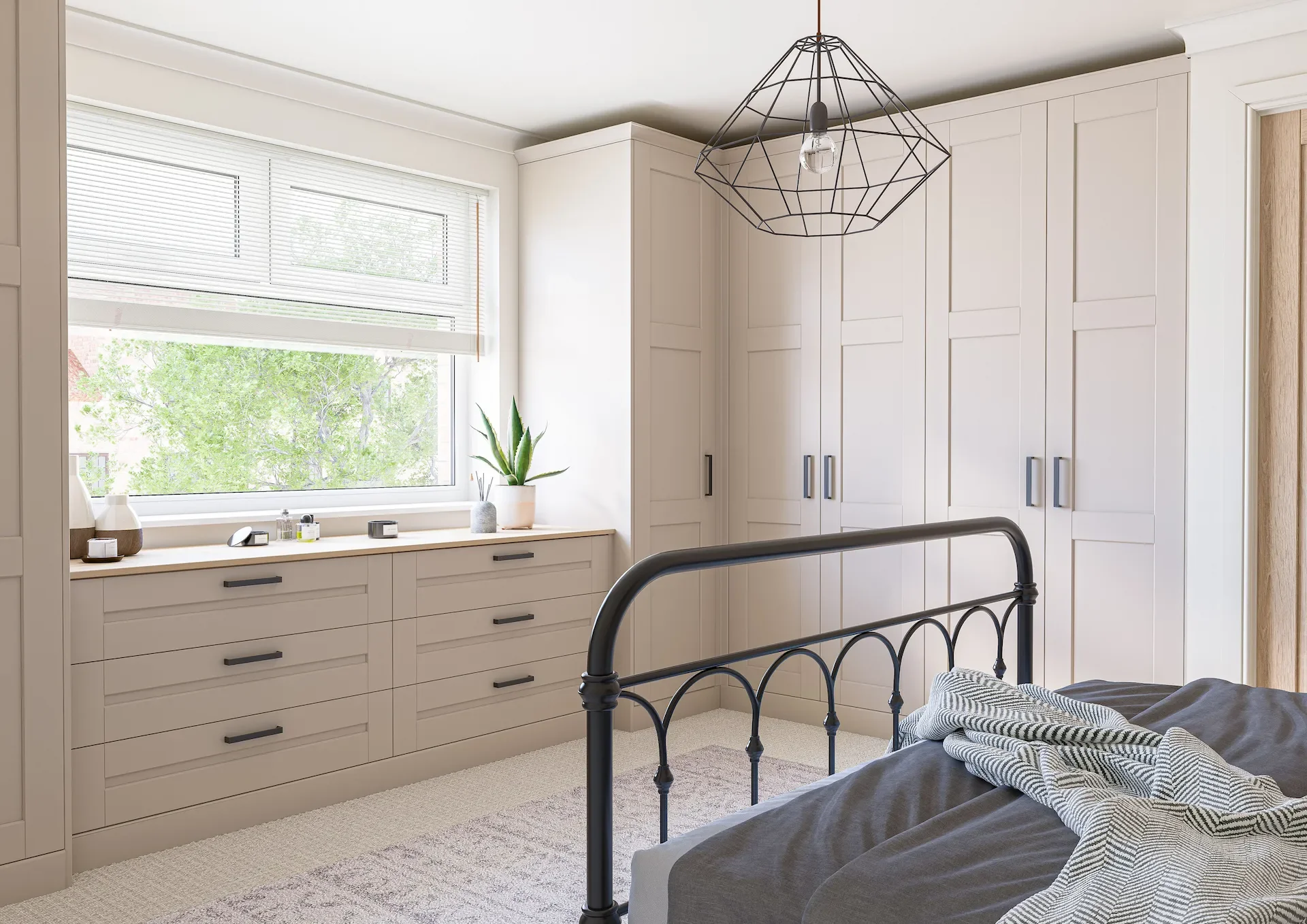 A bedroom with a black metal bed frame, a large window with white blinds, white cabinetry, a window sill with decorative items and a potted plant, and a geometric pendant light hanging from the ceiling.