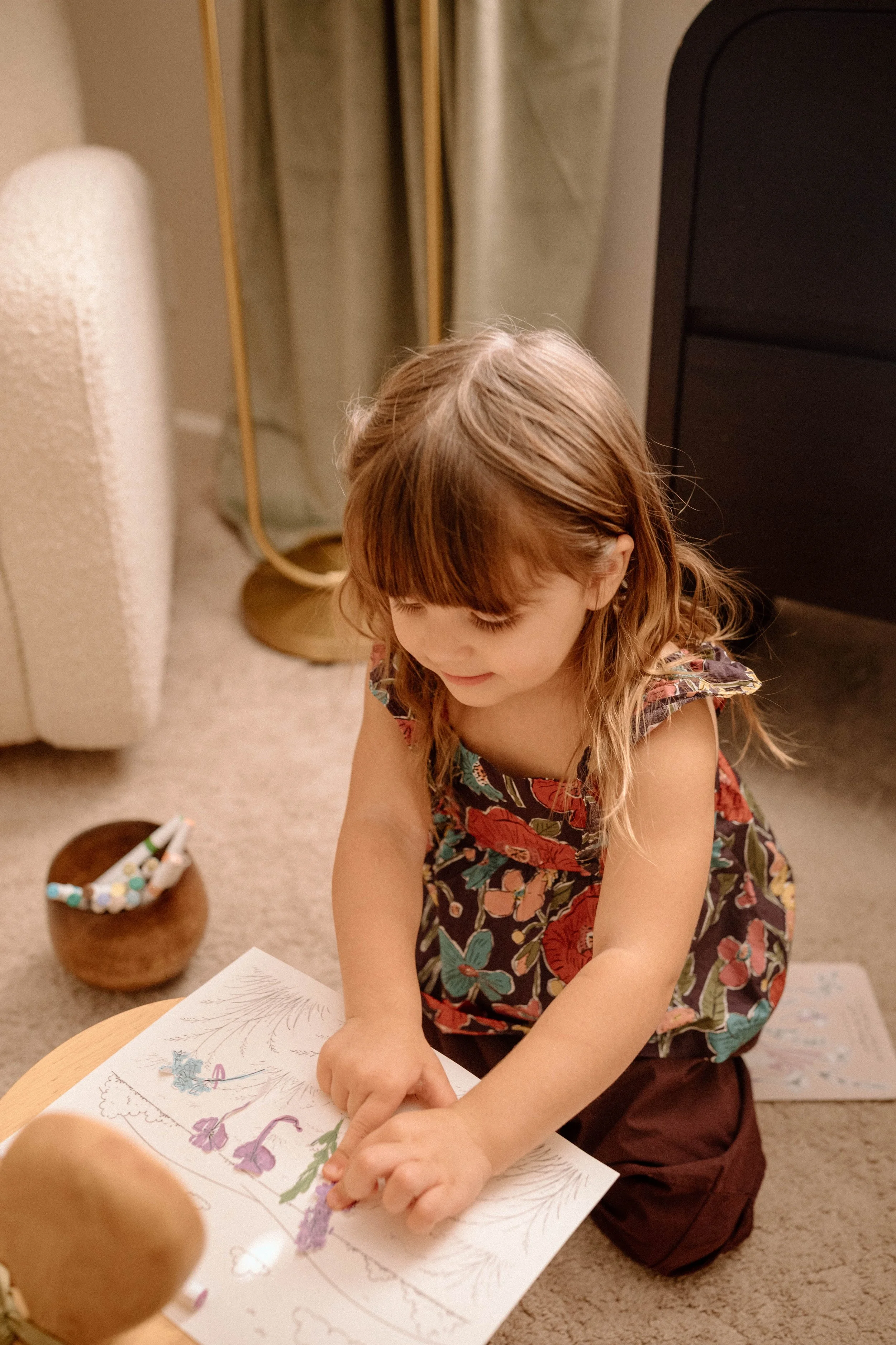 Child coloring and creating with flower stickers from Littles in Bloom.