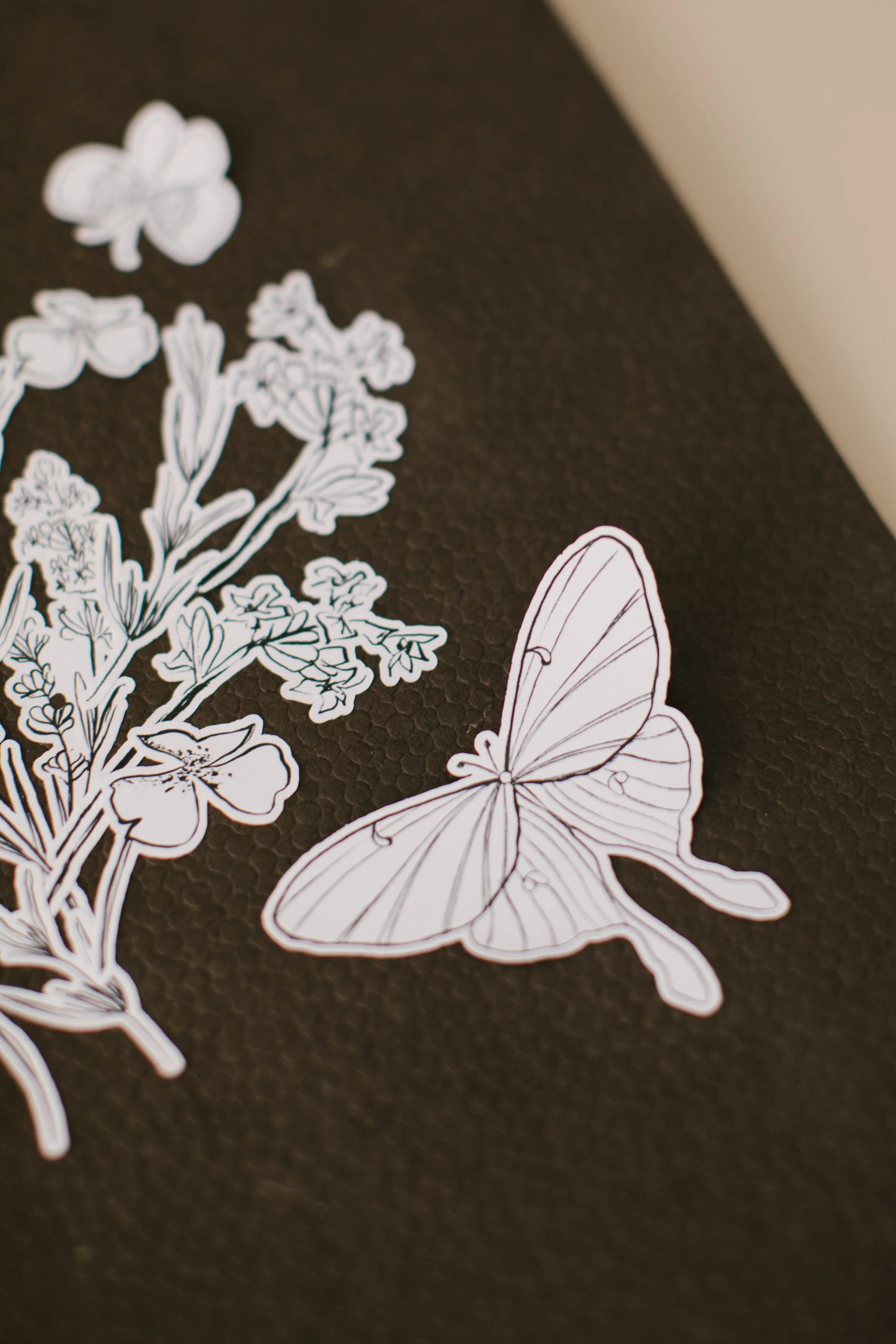 Close-up of illustrated butterfly stickers on the Color + Create sheet.