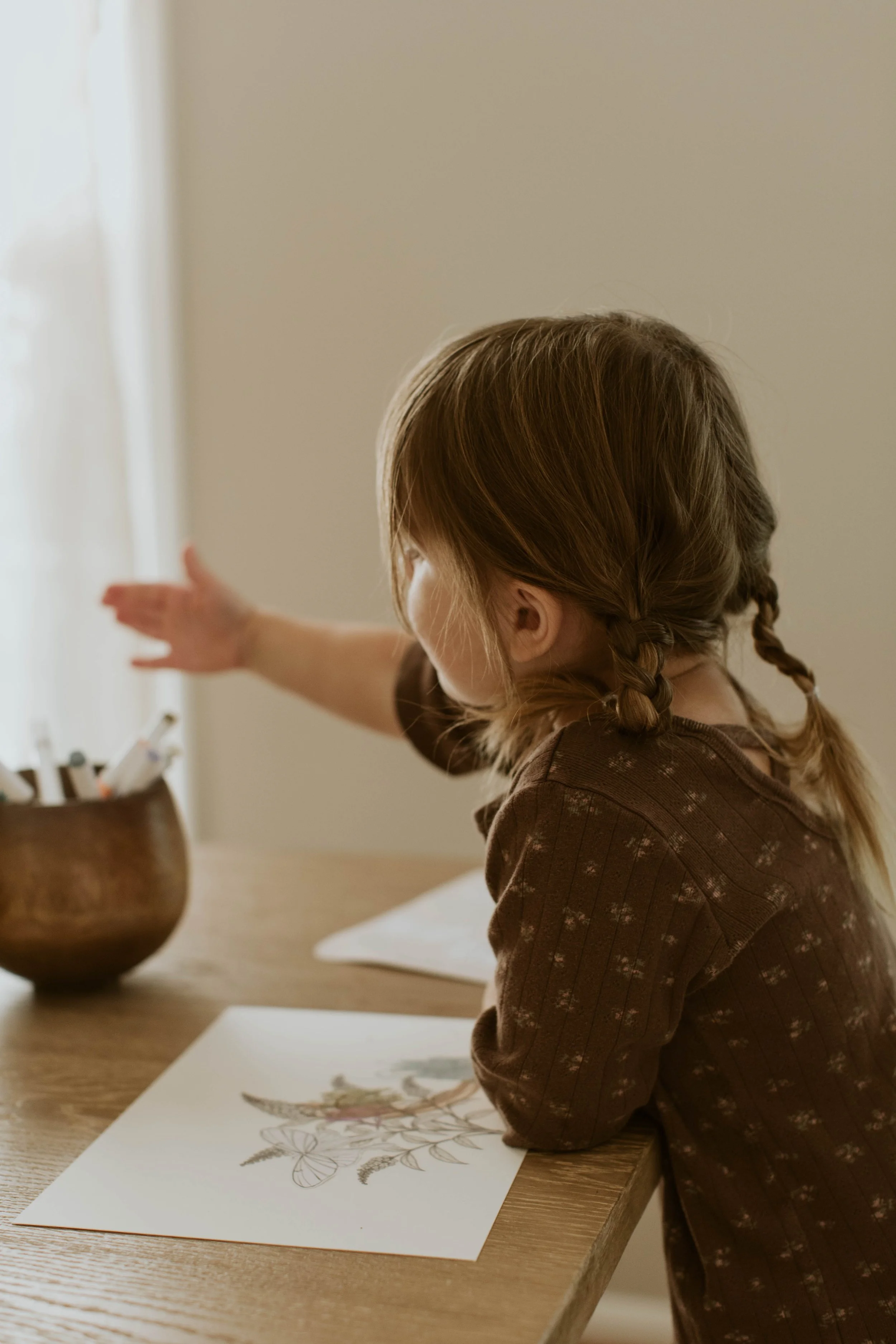 Young child coloring a Butterfly Color + Create activity sheet.
