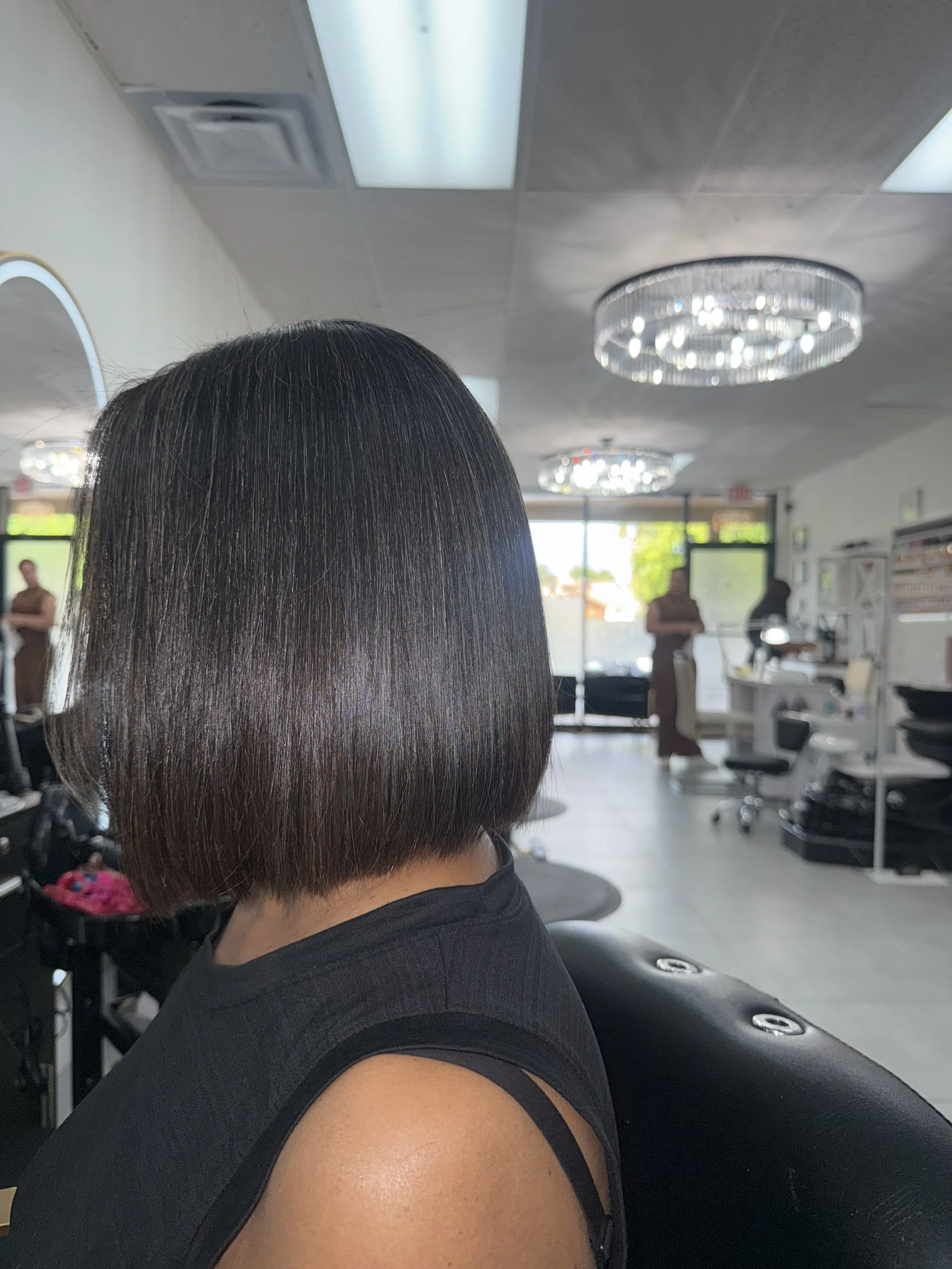 Woman with a short bob haircut sitting in a hair salon.