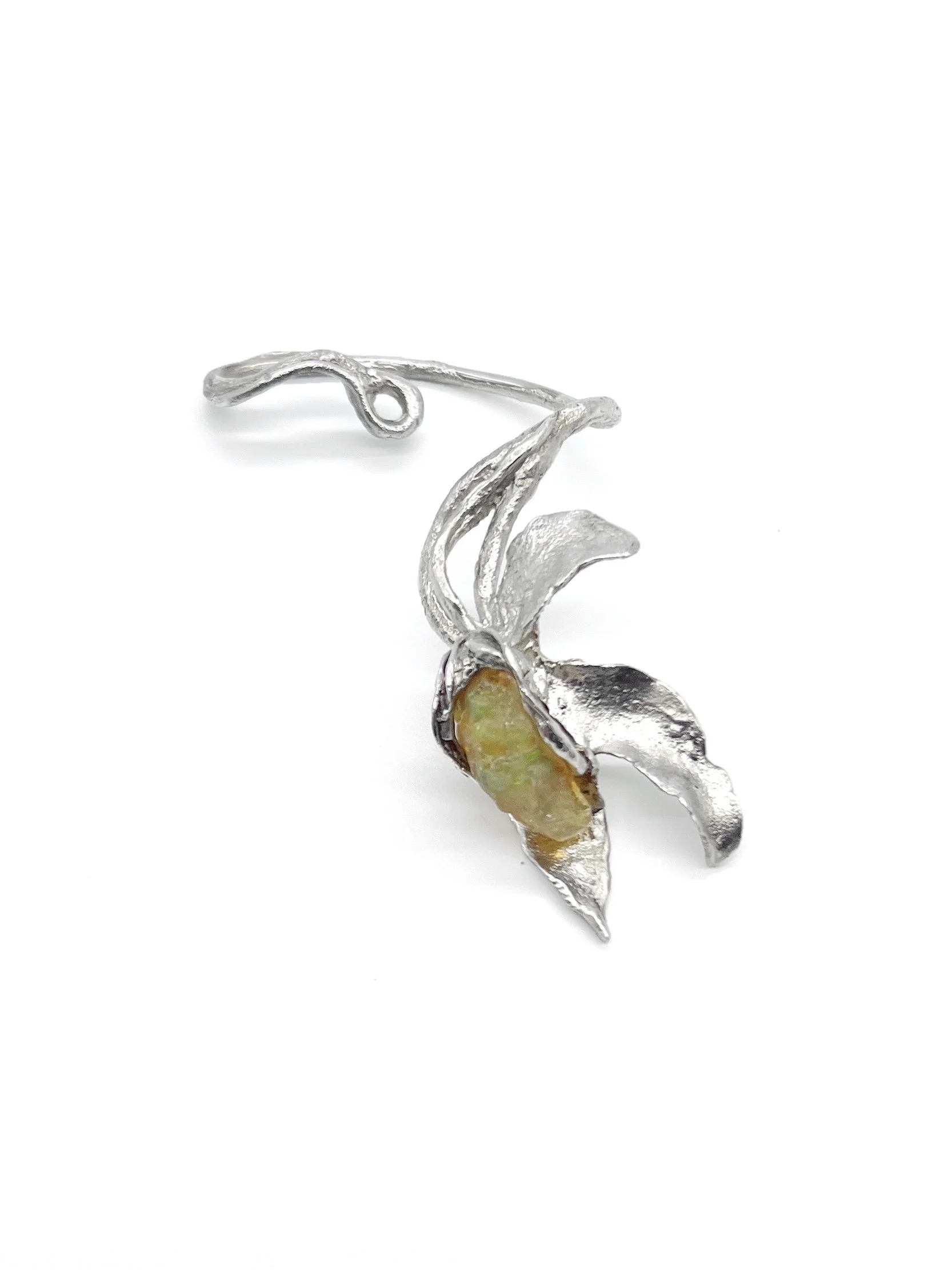 Silver jewelry shaped like a flower with a pale yellow stone in the center and a decorative silver stem.