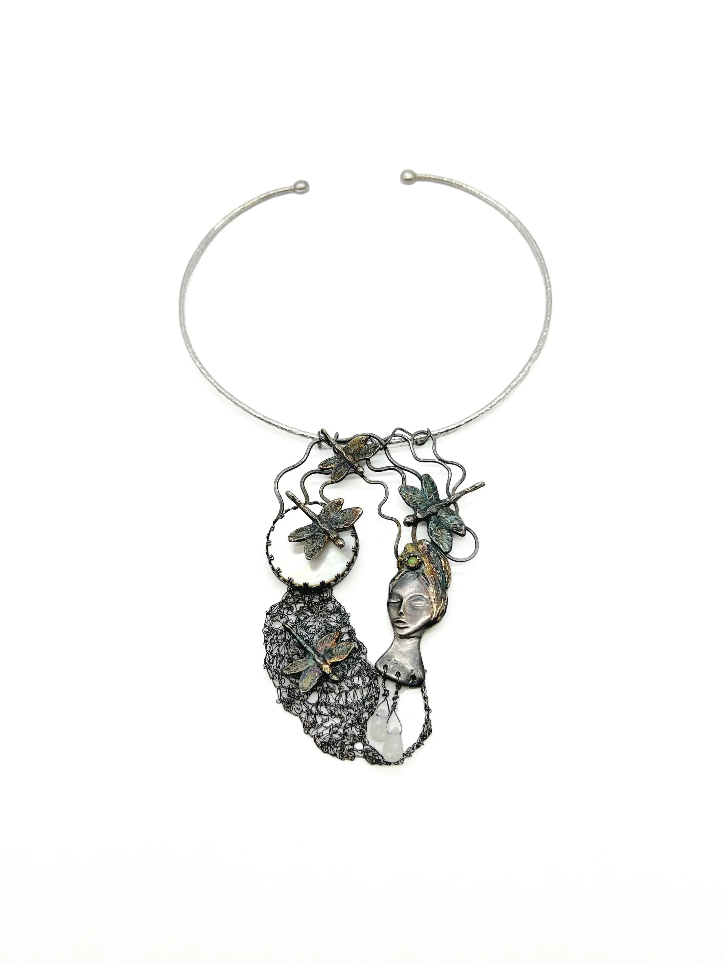 Silver necklace featuring a pendant of a woman's face surrounded by butterflies, with a mesh-like structure hanging below.