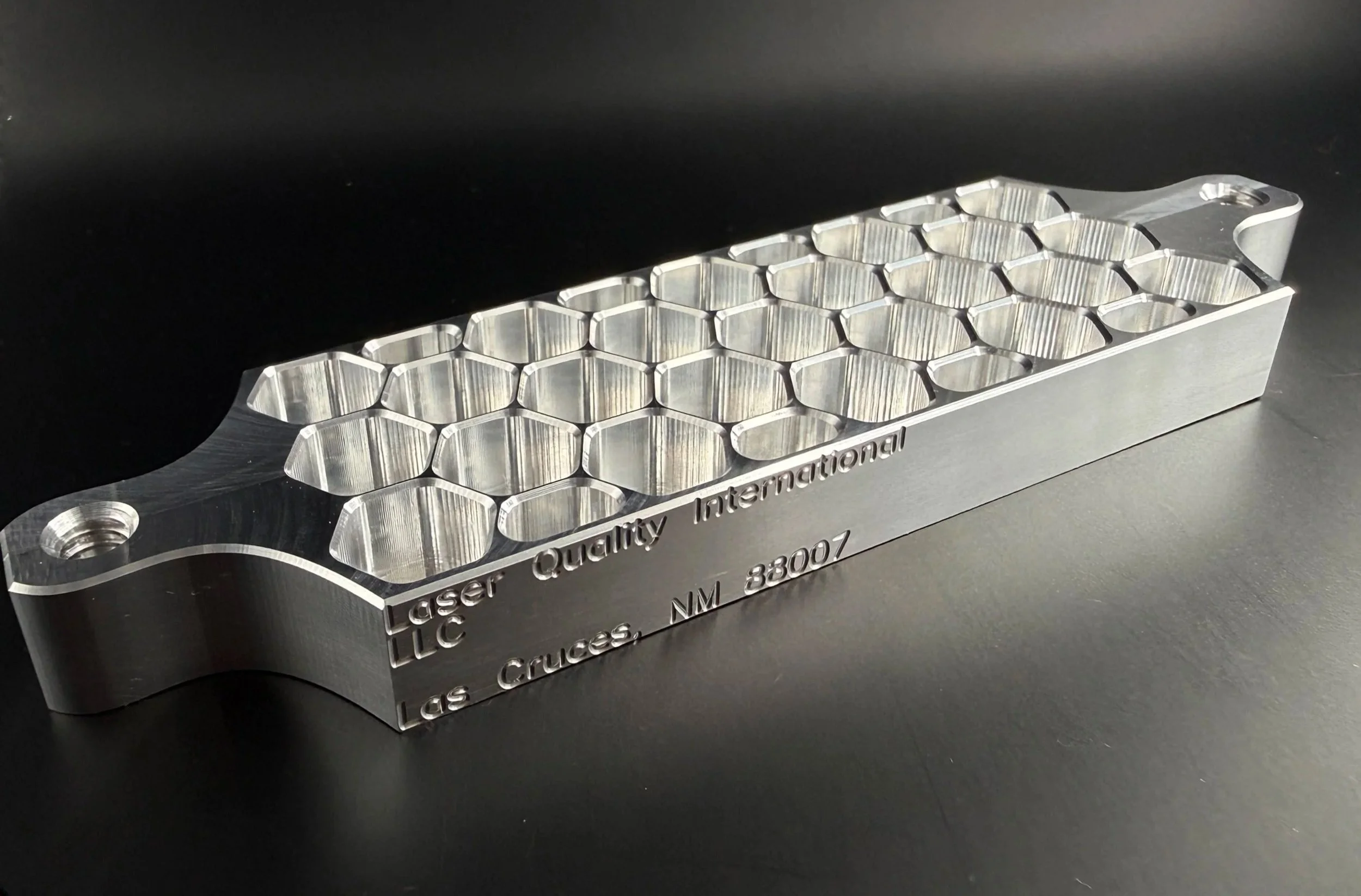 Machined honeycomb component with deep hexagonal pockets and mounting holes.