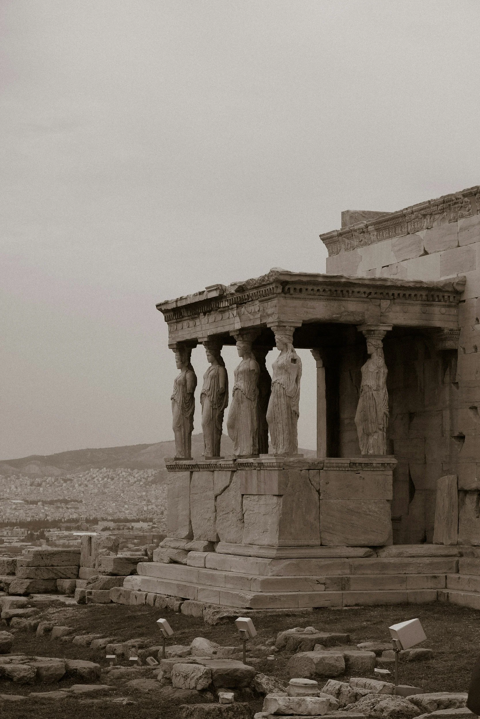 Stone temple with sculpted figures supporting a porch.