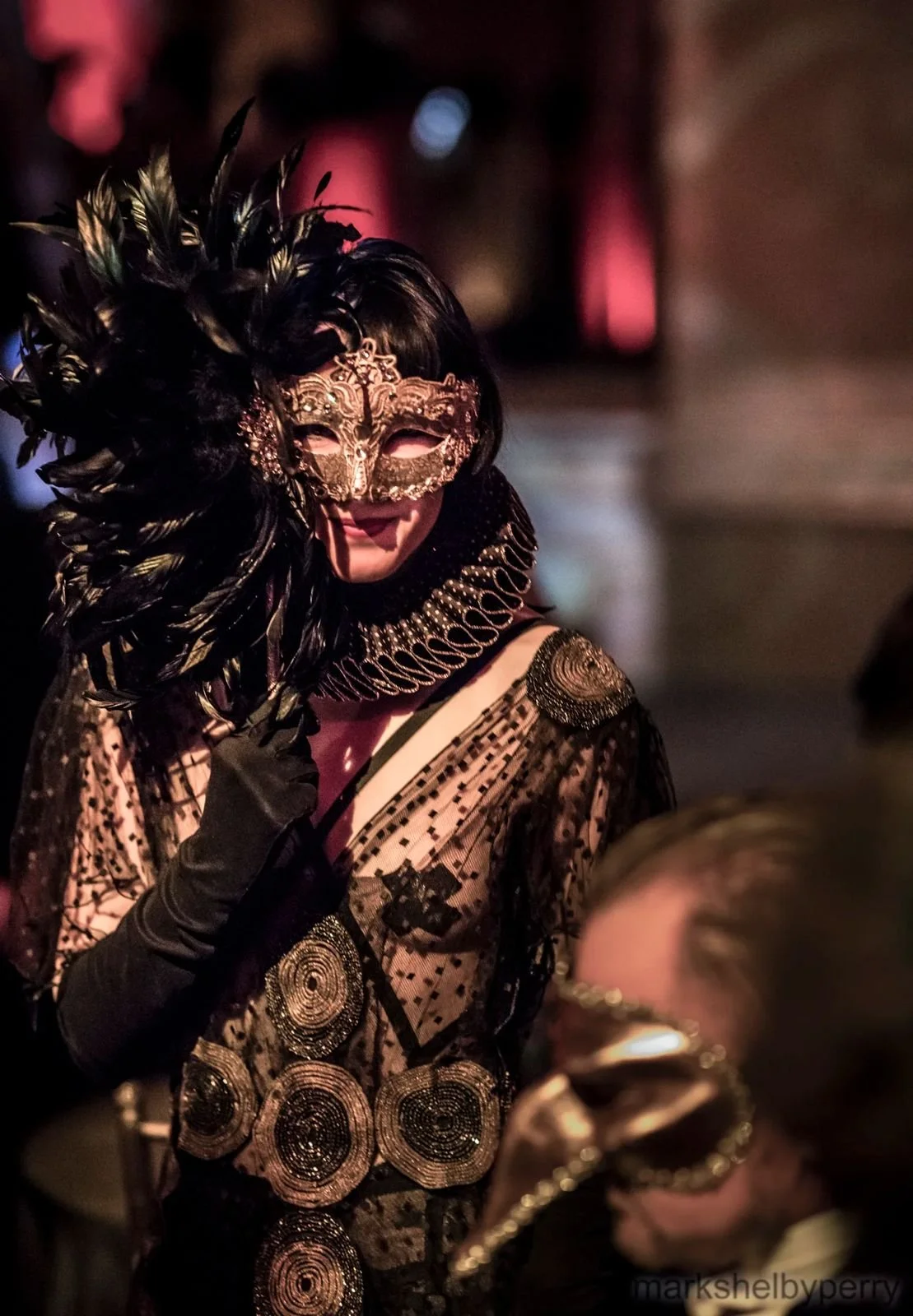 Gold-masked figure in black feathers. Past Astarte Creative performance.