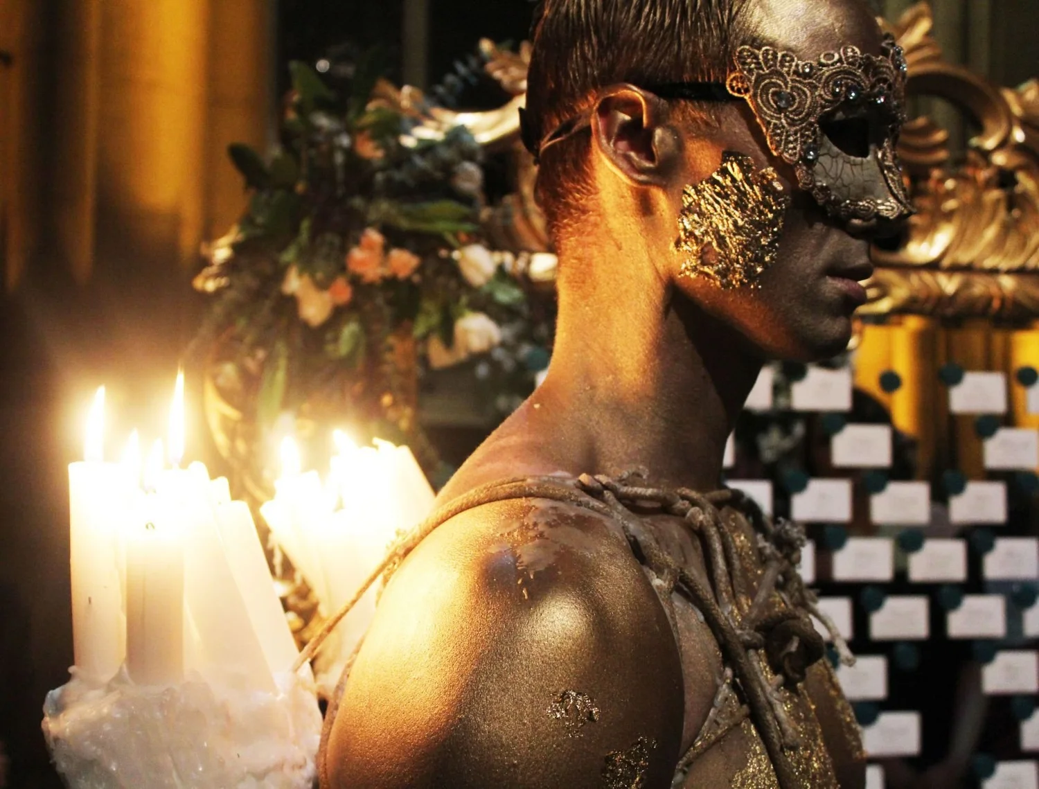 Golden living candelabra beside candles. Past Astarte Creative performance.