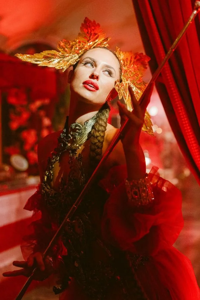 Gold headdress and red gown with staff. Past Astarte Creative performance.
