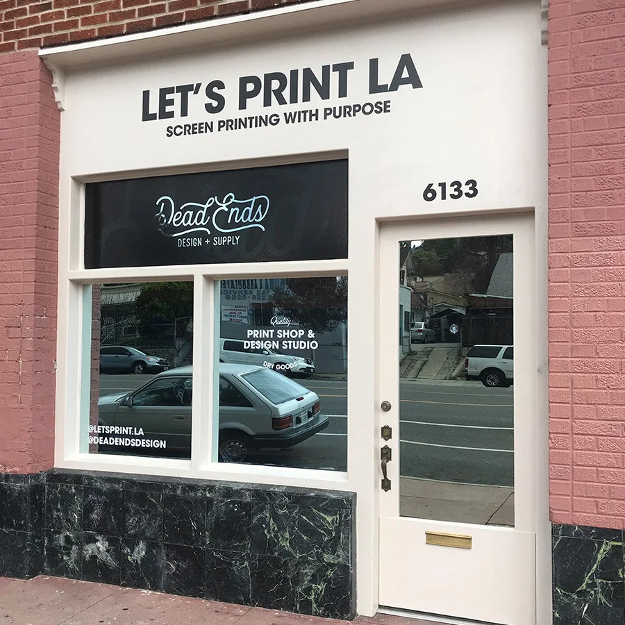The storefront of a print shop with the sign 'Let's Print LA' and the logo 'Dead Ends Design + Supply' on the window, located at 6133 on the street.