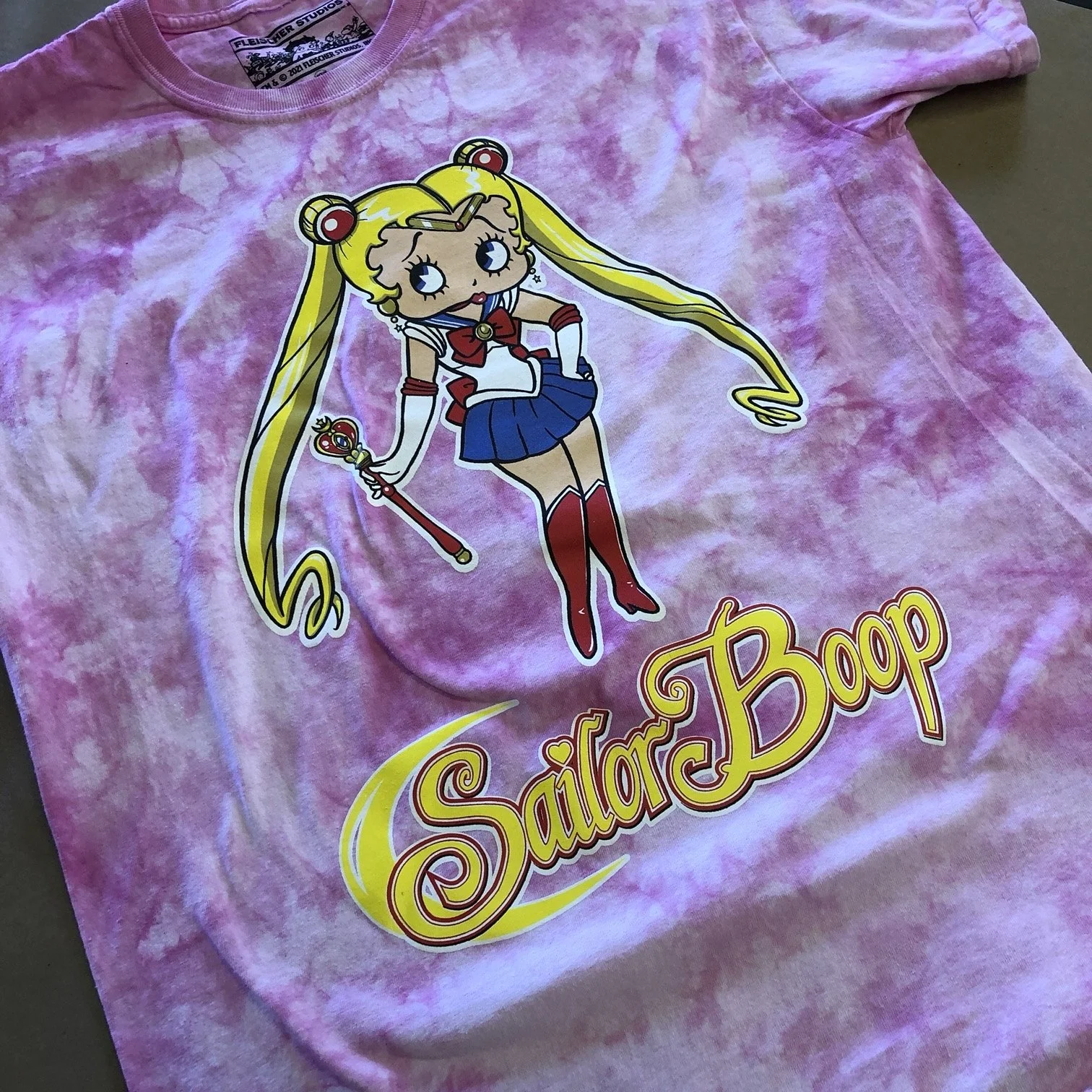 Pink tie-dye T-shirt with a graphic of Sailor Moon holding a scepter, and the words "Sailor Boop" in stylized yellow and red lettering.