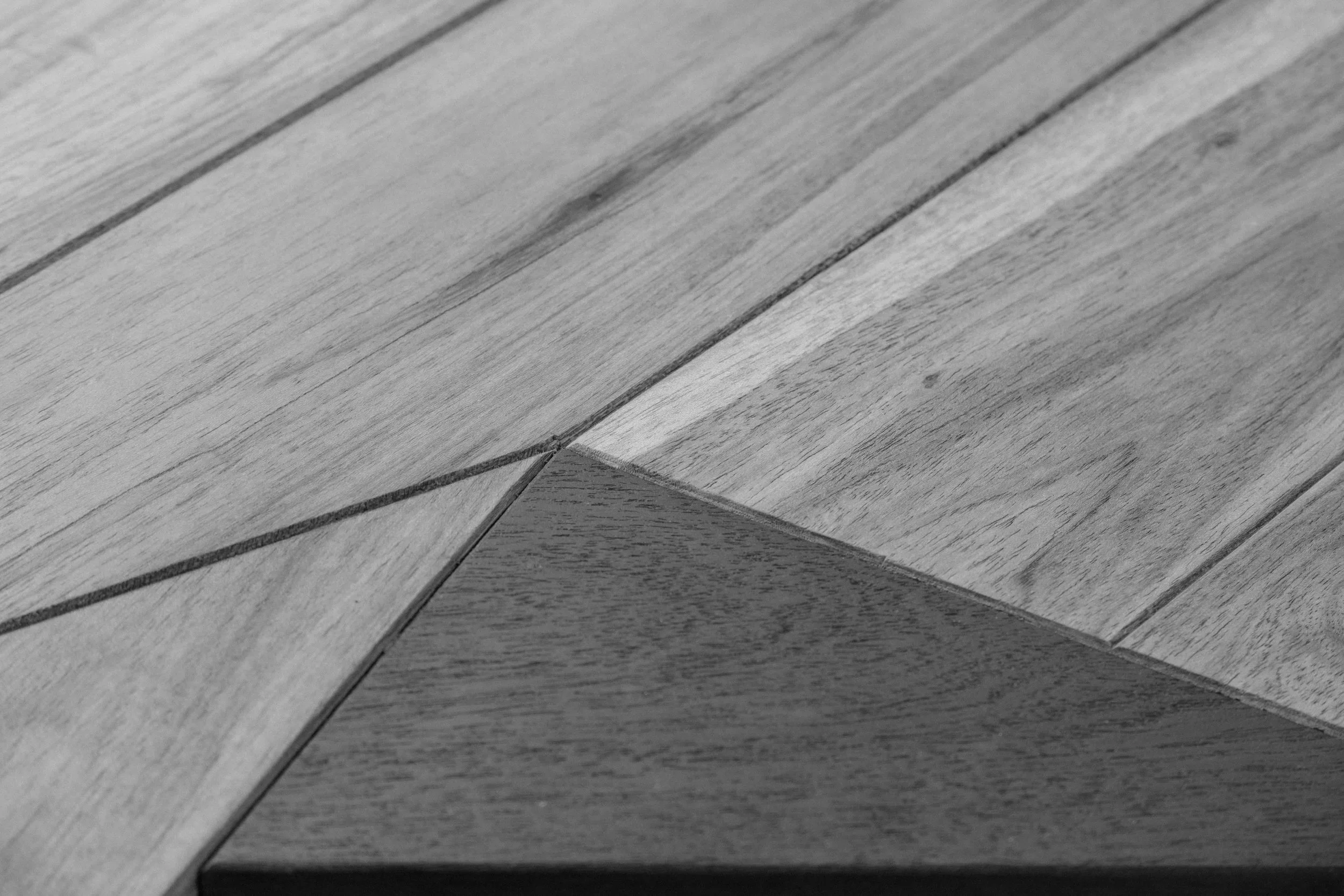 Planche de bois en bois clair avec un joint entre deux morceaux, vu en gros plan.