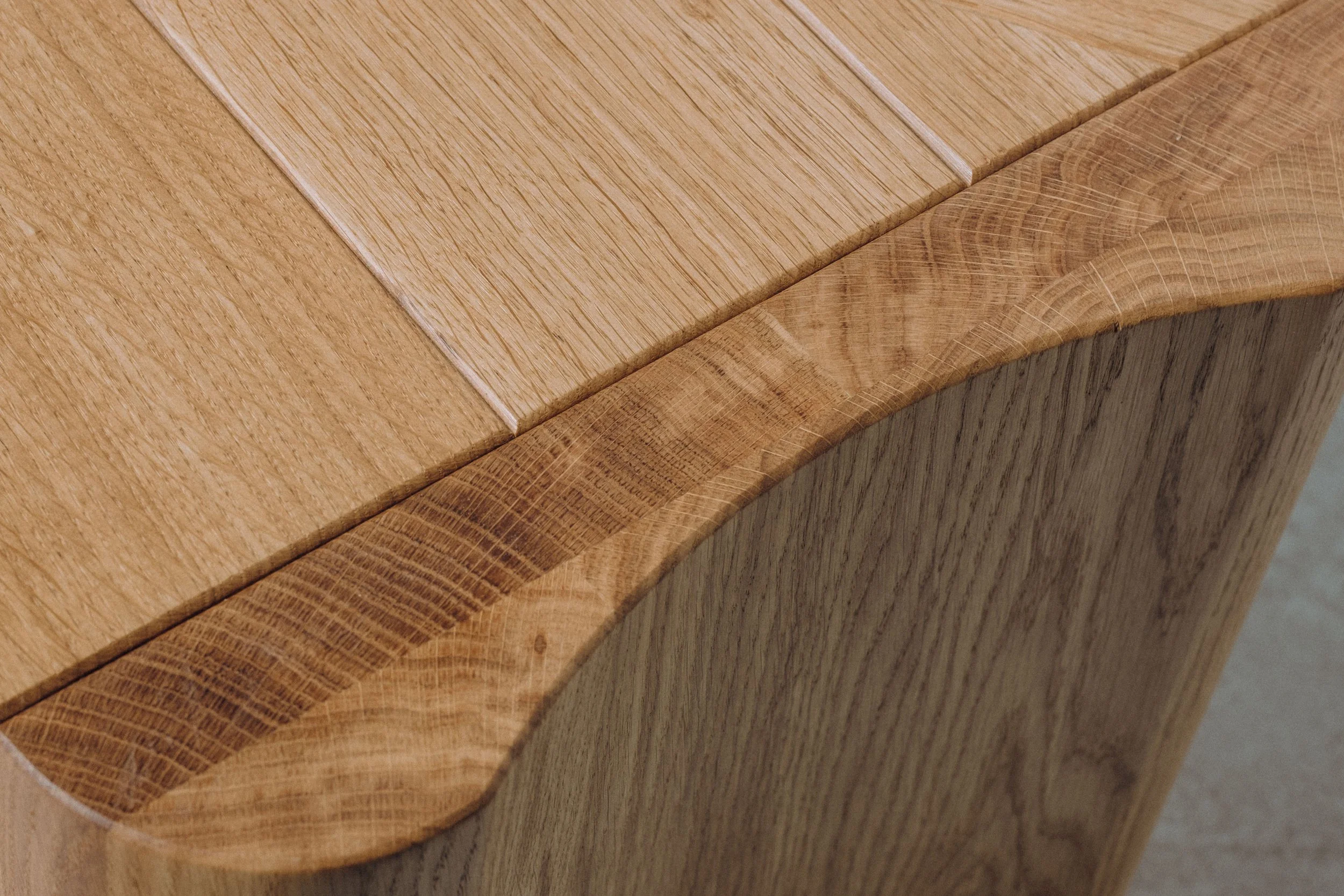 Gros plan d'une surface en bois, montrant le grain et les détails de la texture, avec une finition lisse et polie.
