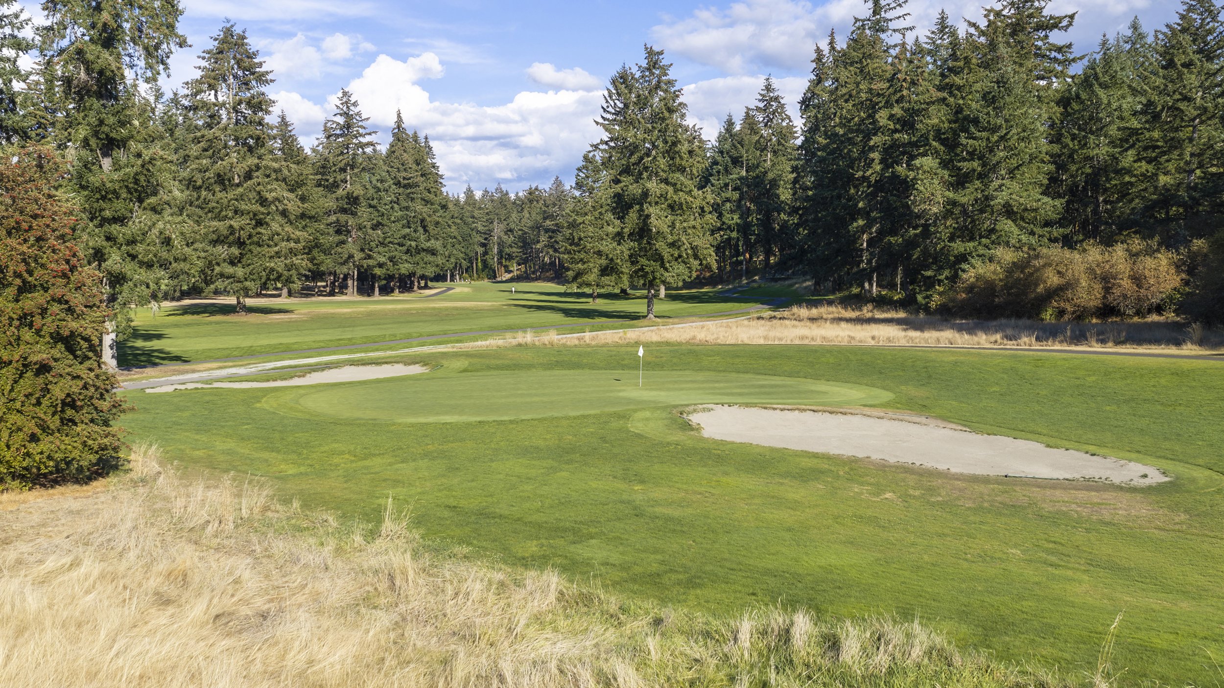 Hole 11 at American Lake Veterans Golf Course, a green with a flag and sand bunkers.