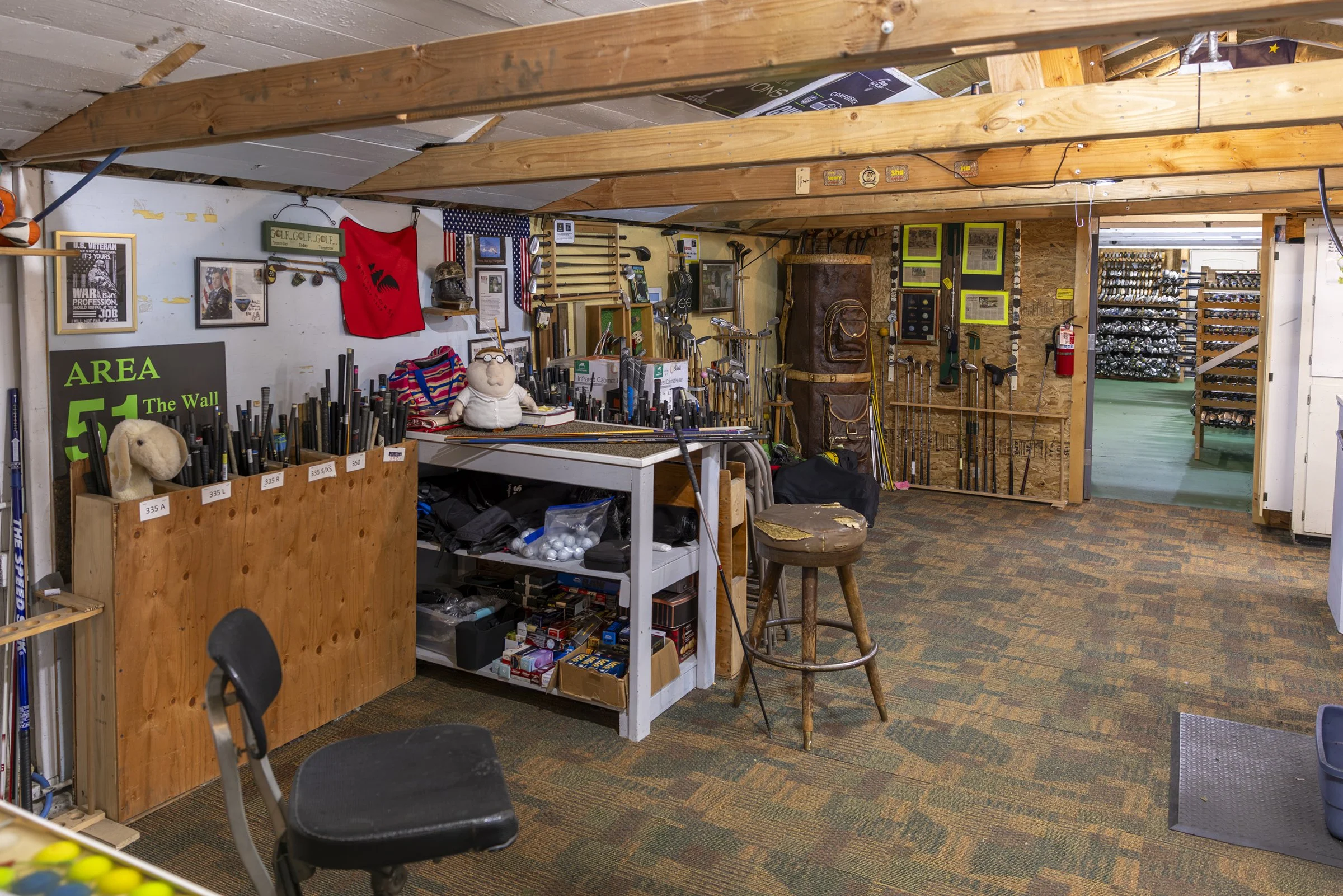 Inside the Area 51 workshop, with a work table, tools and memorabilia on the walls