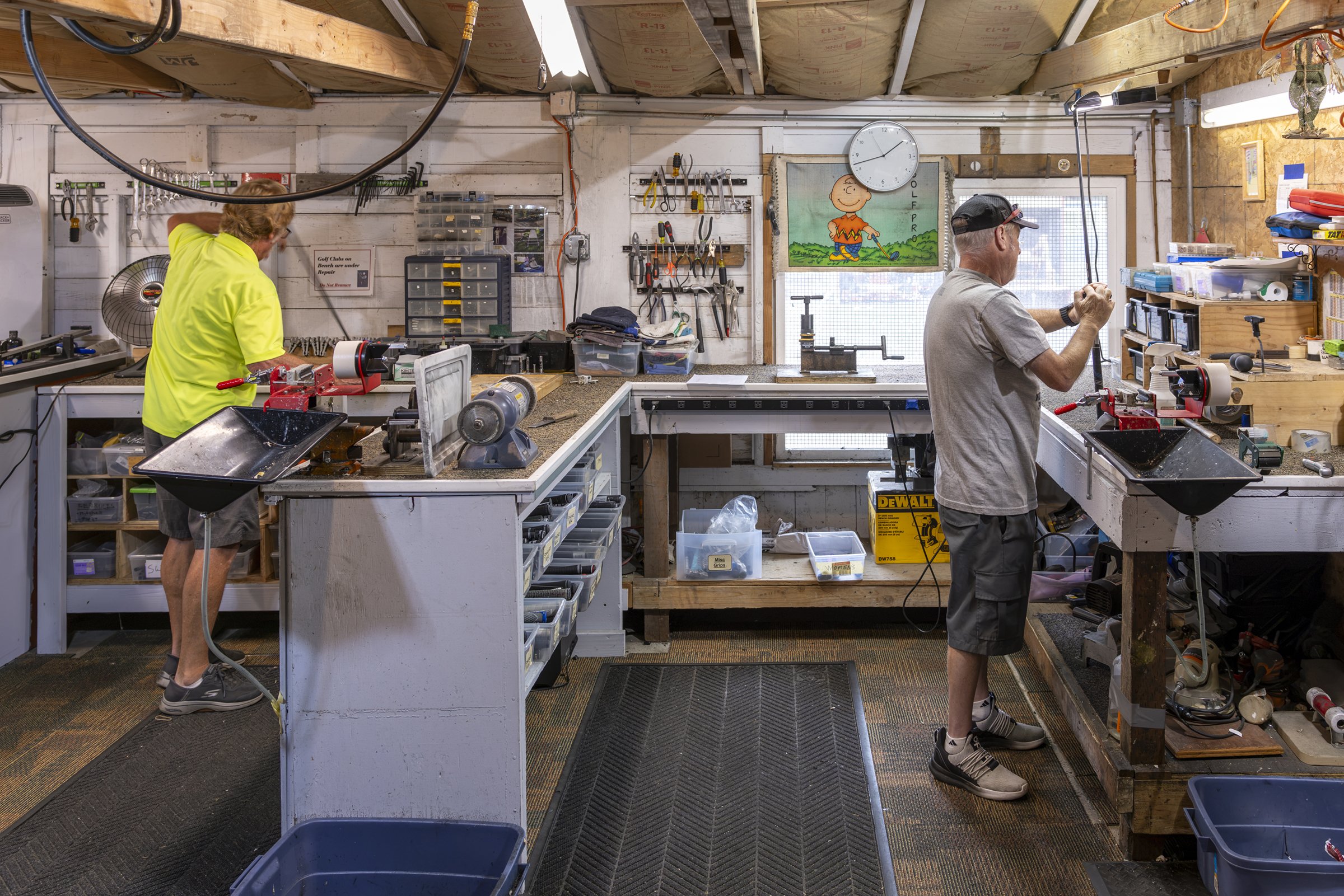 An Area 51 volunteer at the workbench repairing golf clubs