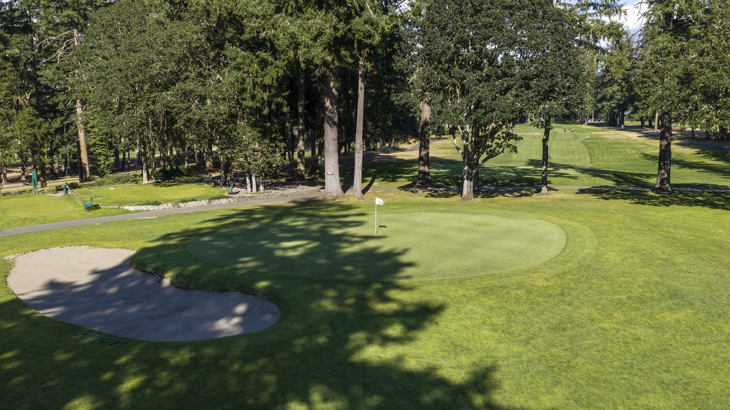 Hole 2 at American Lake Veterans Golf Course, showing the green, greenside bunker and tree-lined fairway in Lakewood, Washington.
