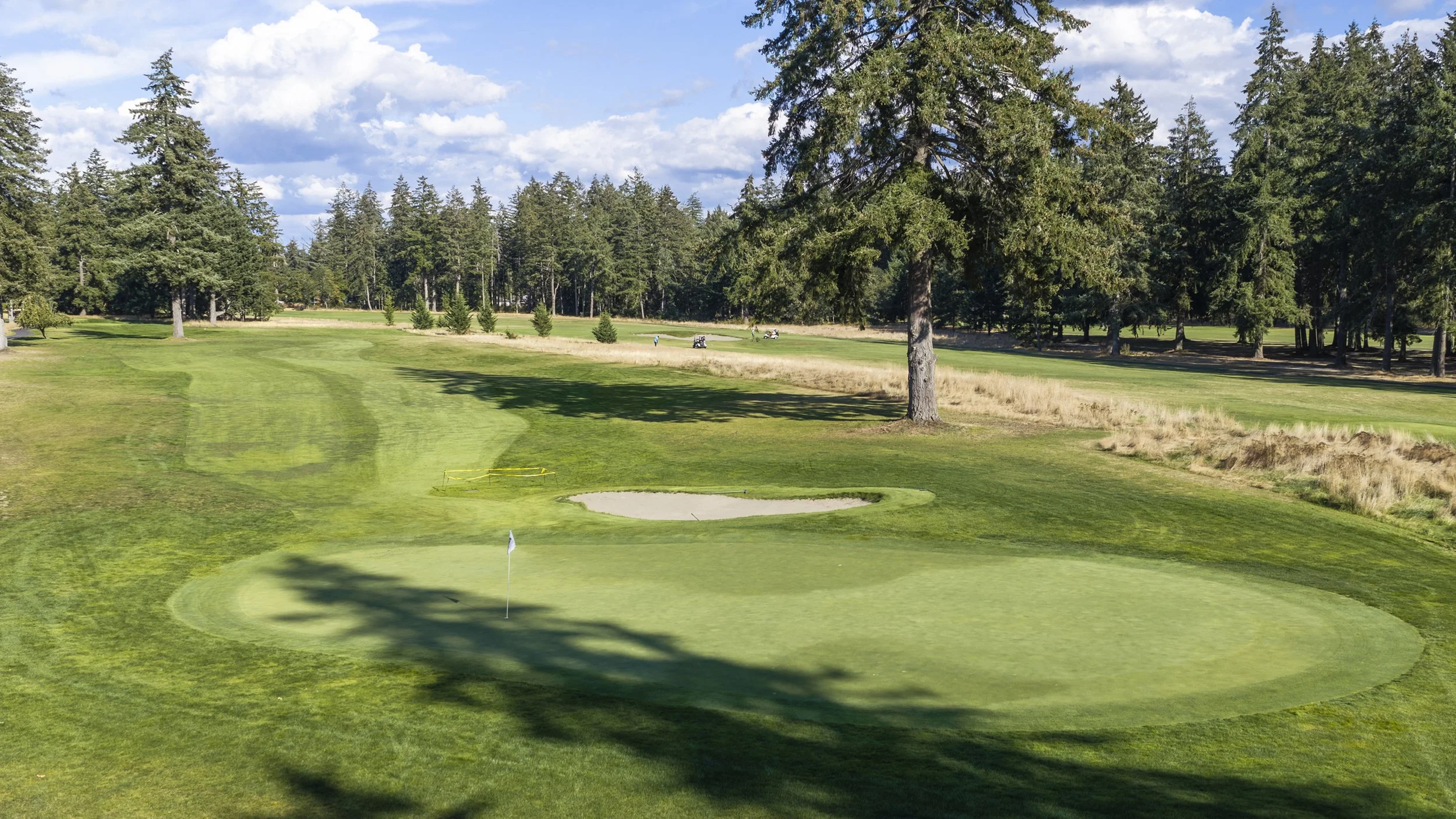Hole 13 at American Lake Veterans Golf Course, a green with a bunker and a flag.