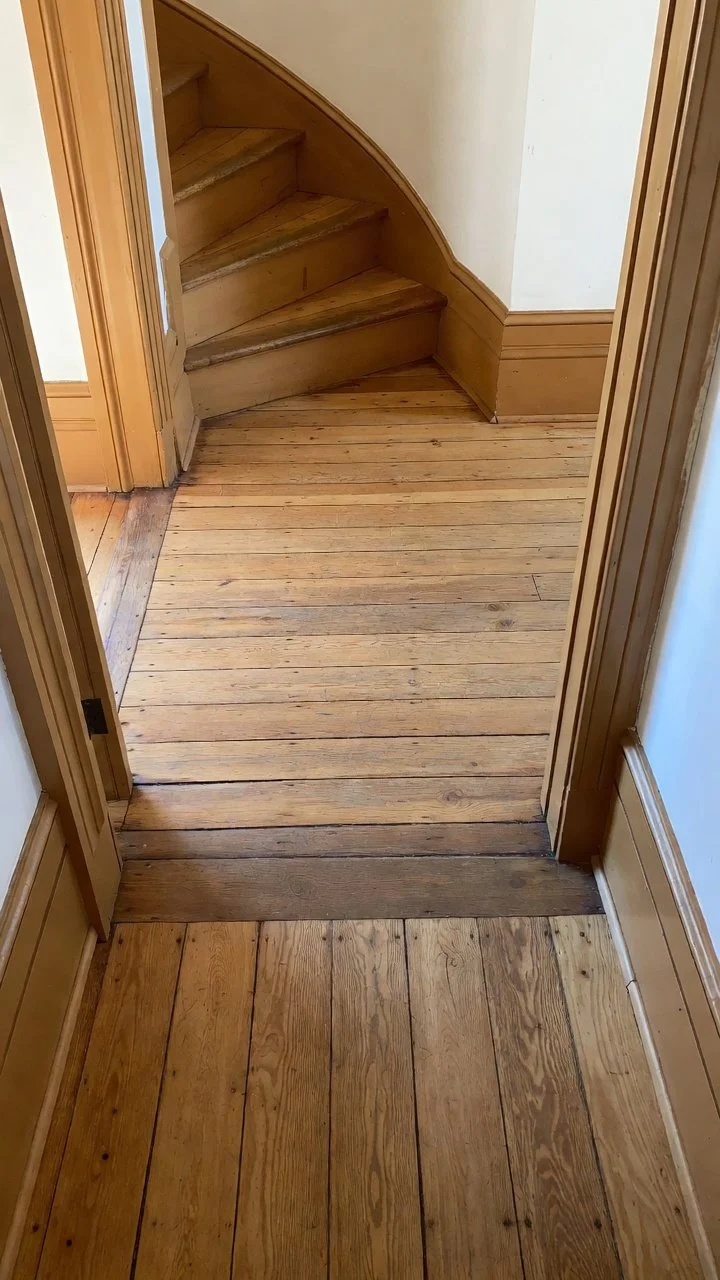 Wooden floor leading to a curved staircase in a house, restoration.