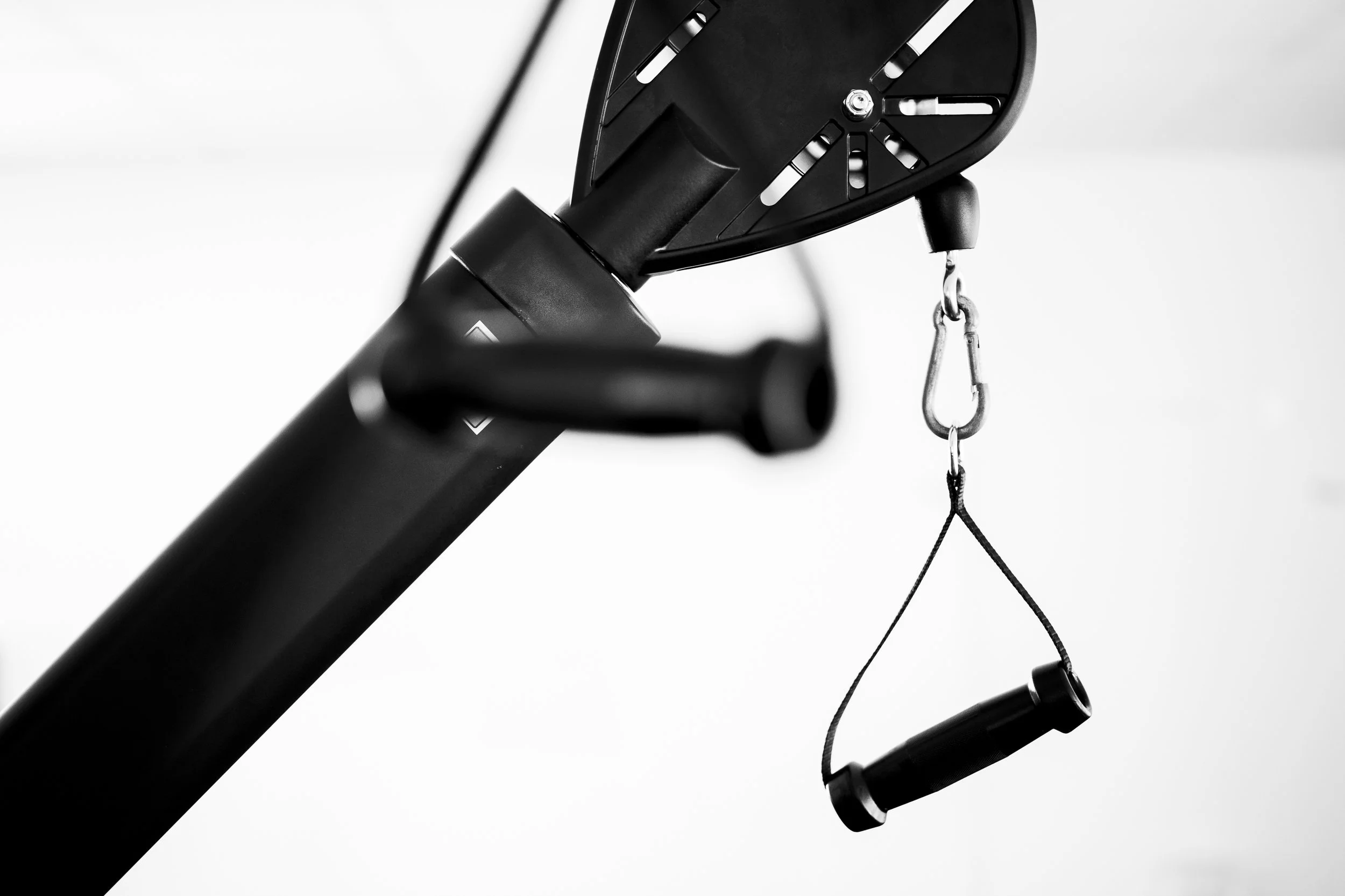Close-up of a treadmill with its safety key and lanyard hanging from the console, black and white