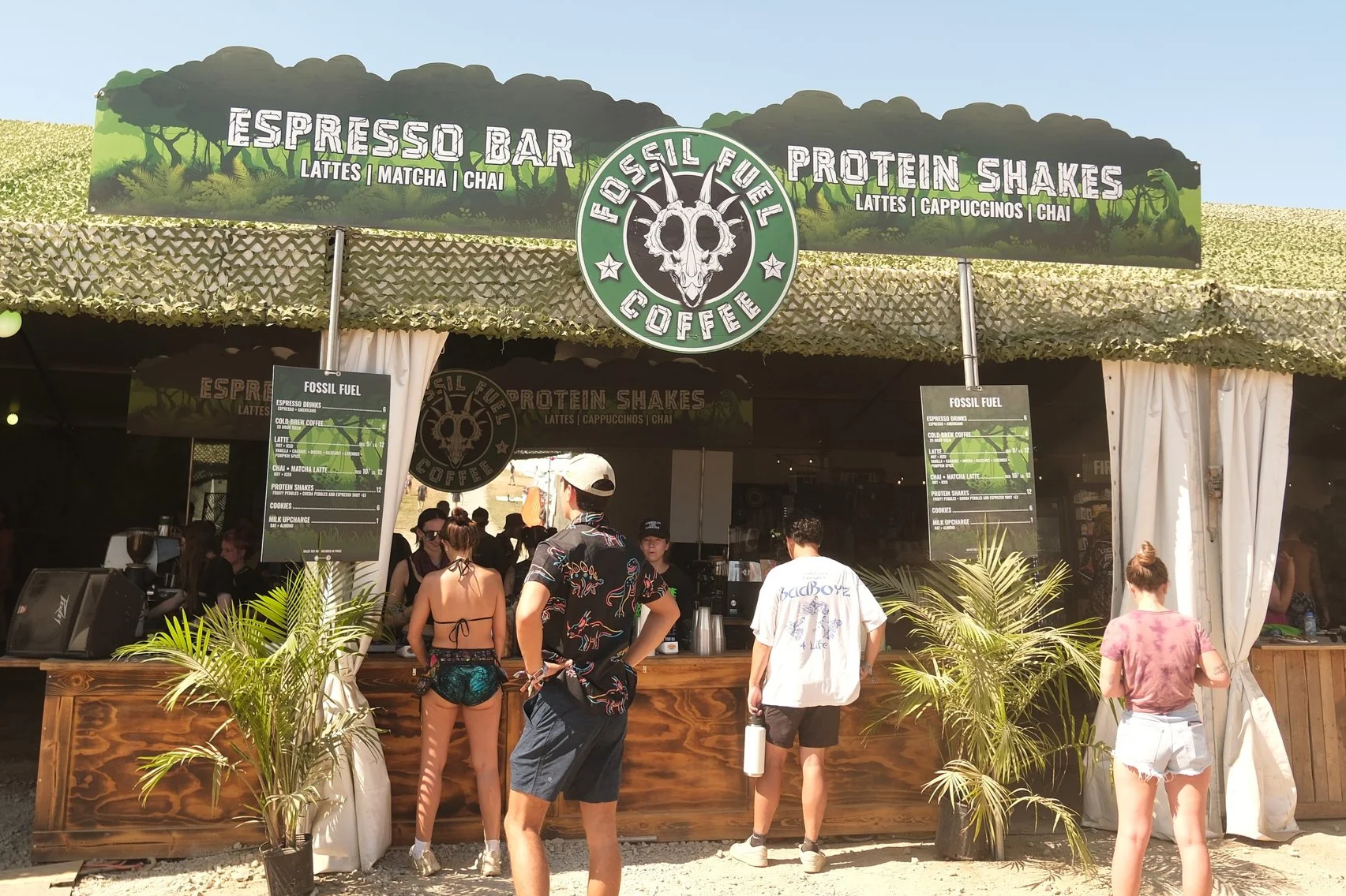 Fossil Fuel Coffee espresso bar with menus, tropical plants, and customers ordering drinks