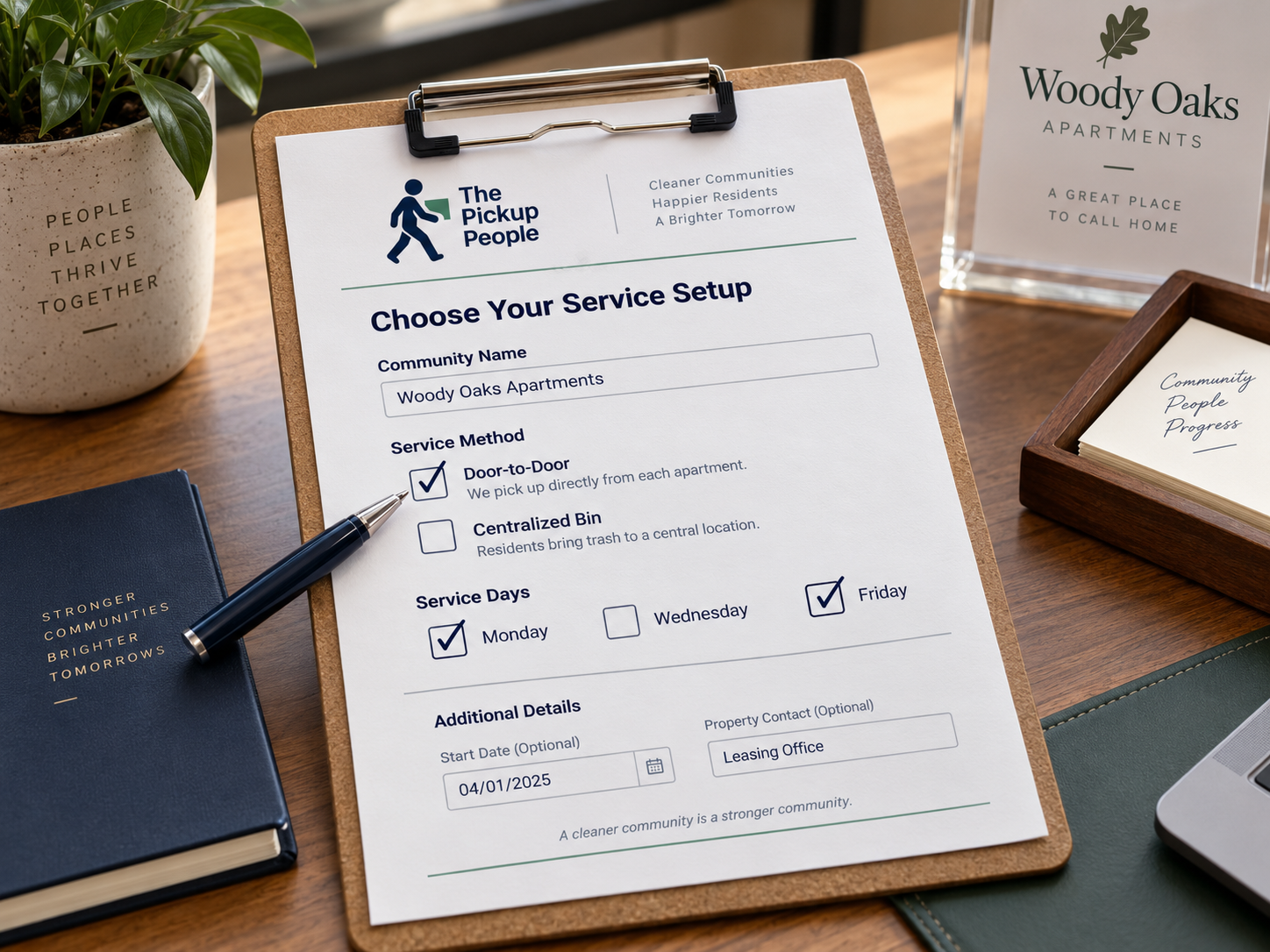 A clipboard with a service setup form for Woody Oaks Apartments, including options for service method, days, an optional start date, and property contact. Surrounding items include plants, notebooks, a pen, and framed signs.