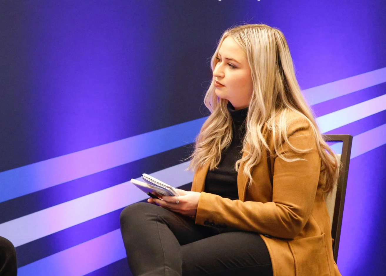 Alexandra Skores holding a notepad and pen during an interview.