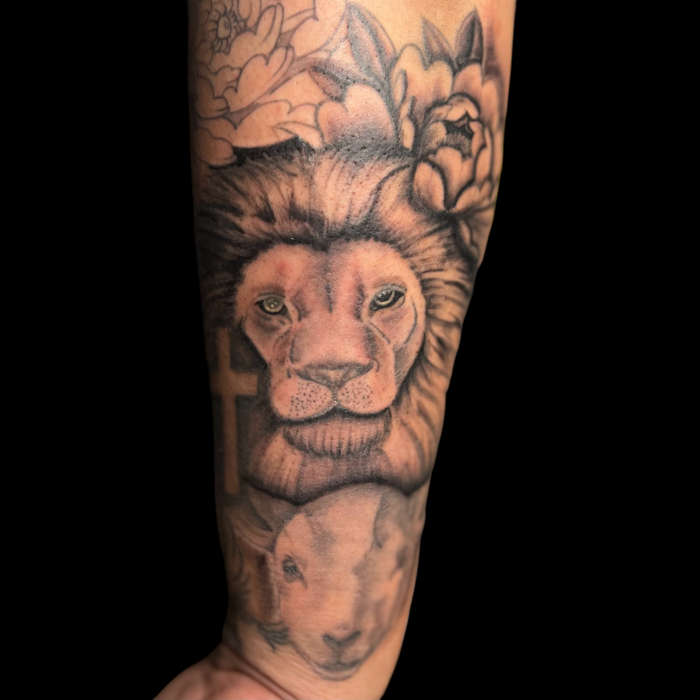 Black and grey illustrative lion and lamb, forearm