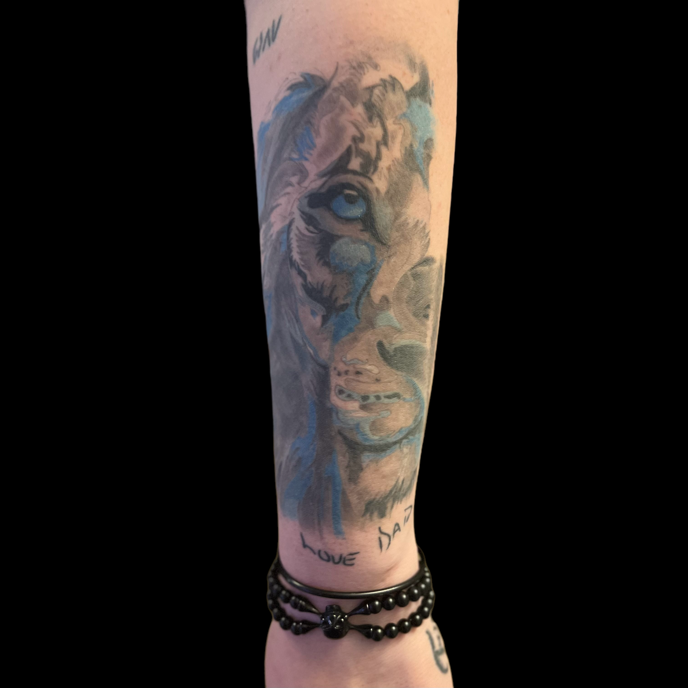Black, grey and blue lion face, forearm