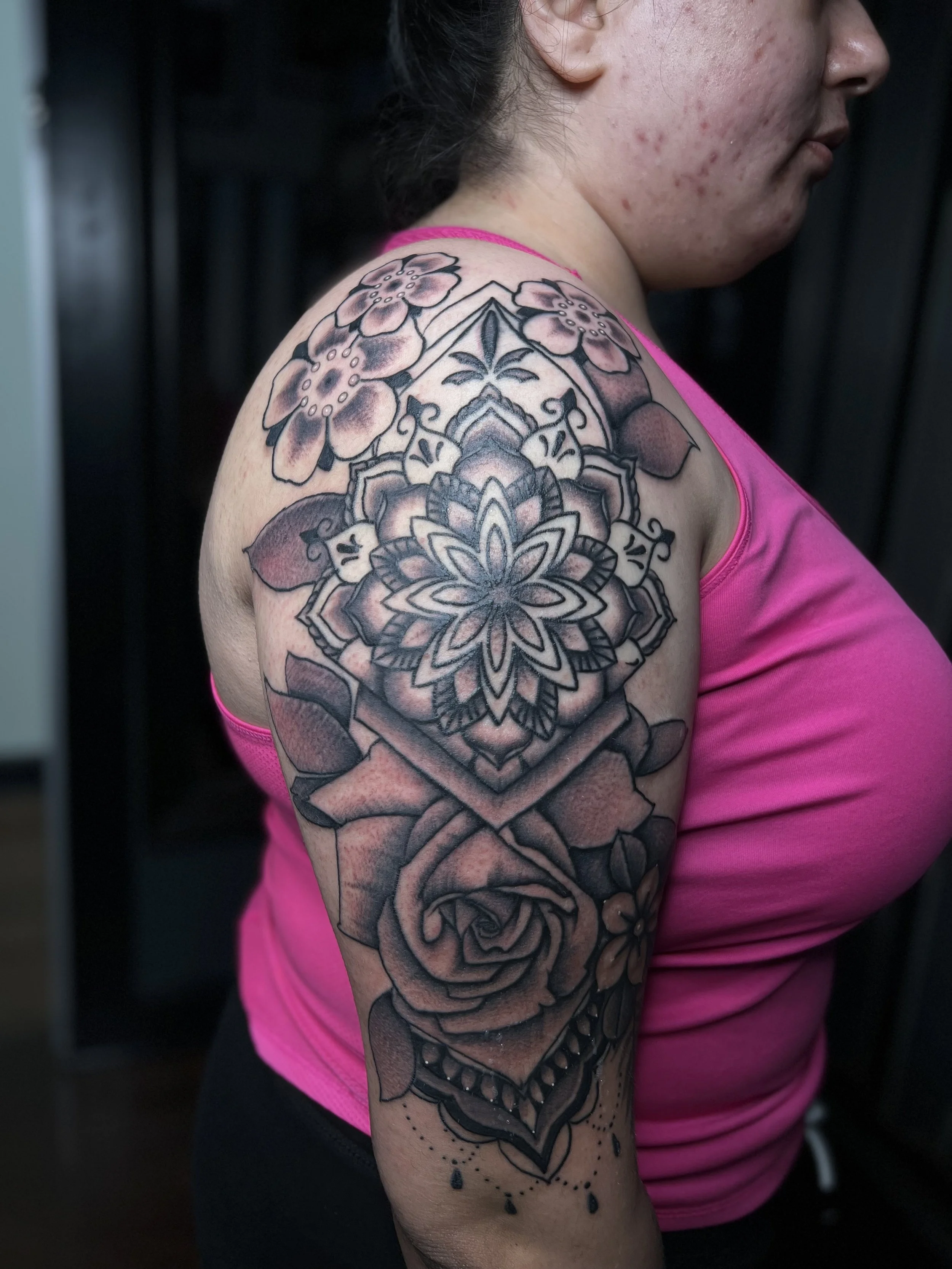 Black and grey illustrative rose and mandala, on upper arm