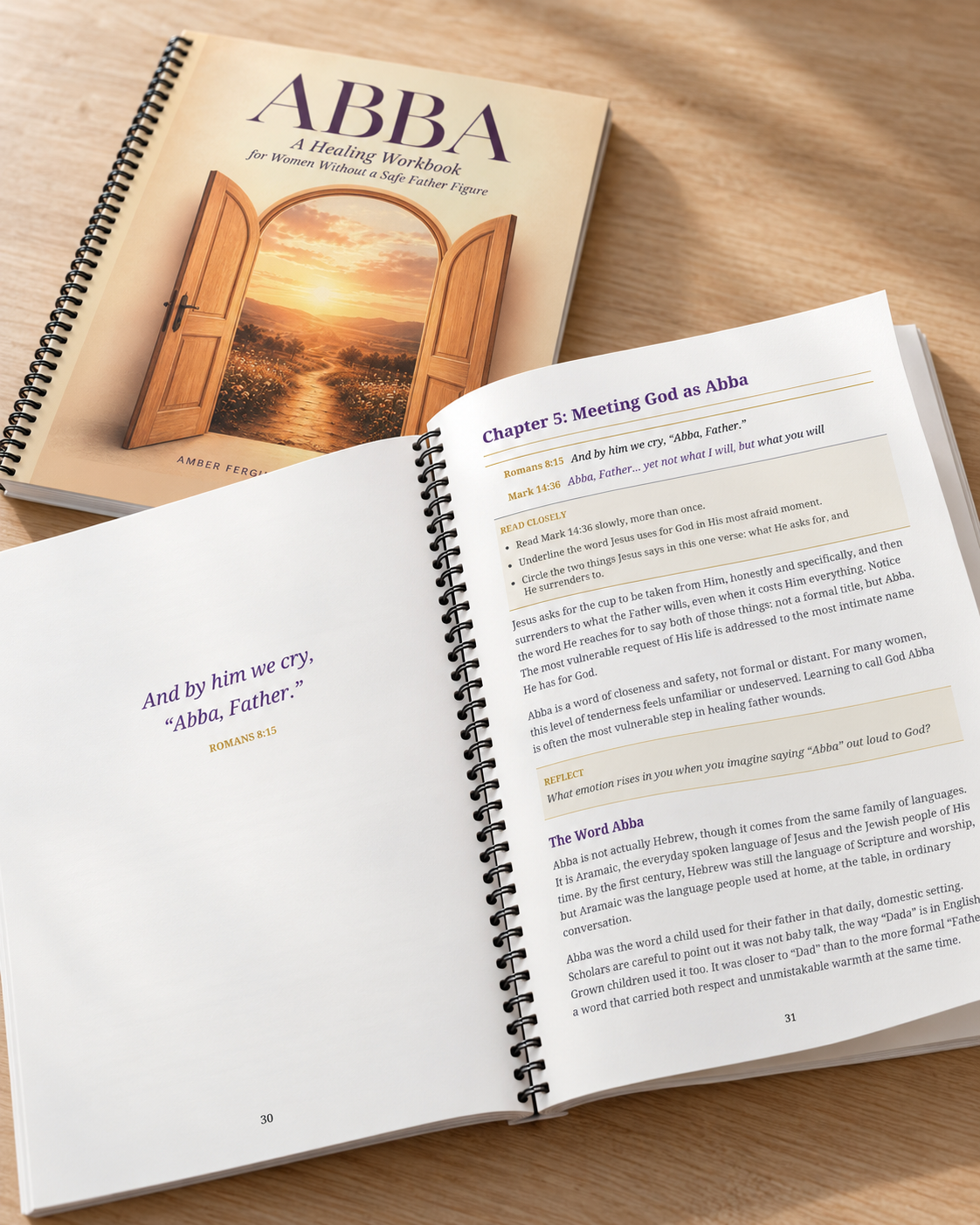 Open Bible and workbook on a wooden table, open to a chapter about meeting God as Abba, with a sunset landscape on the workbook cover.