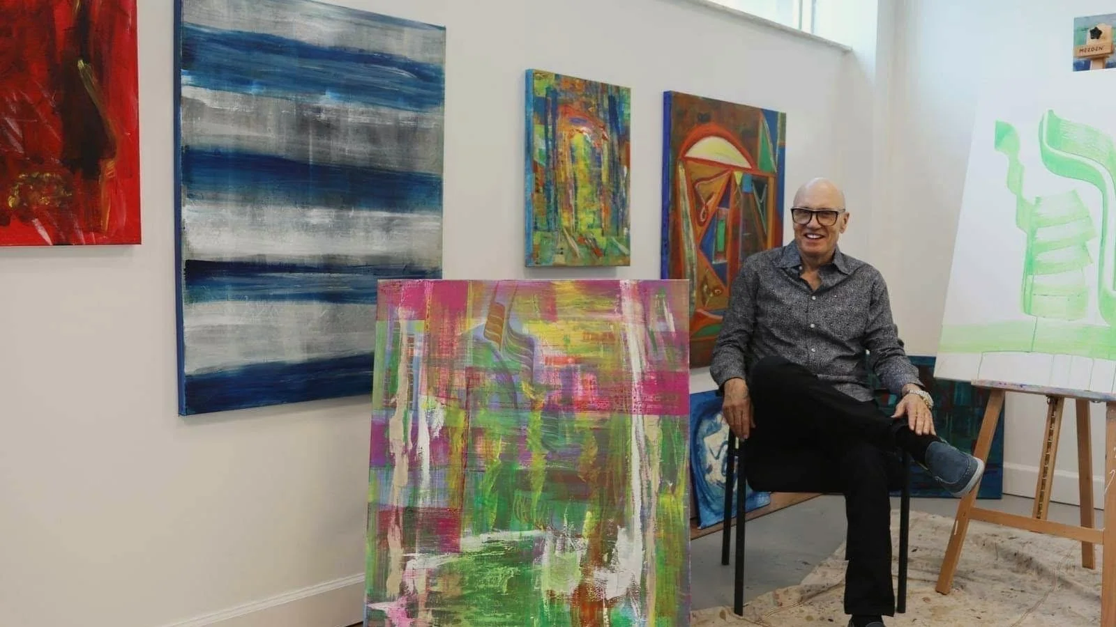 James Kenton Pierce seated in his studio among recent paintings.