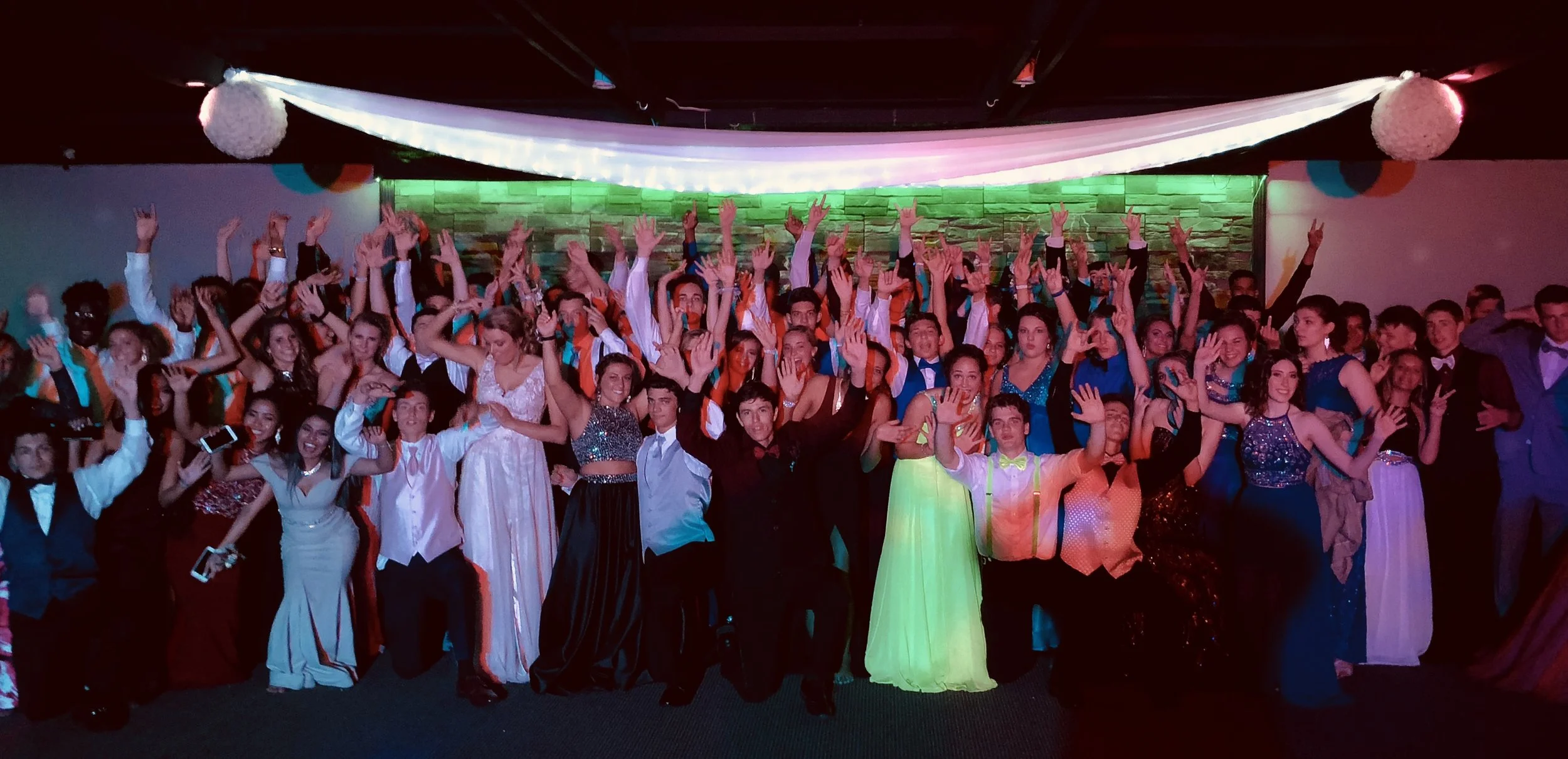 Heritage High School prom guests cheering together in formalwear.