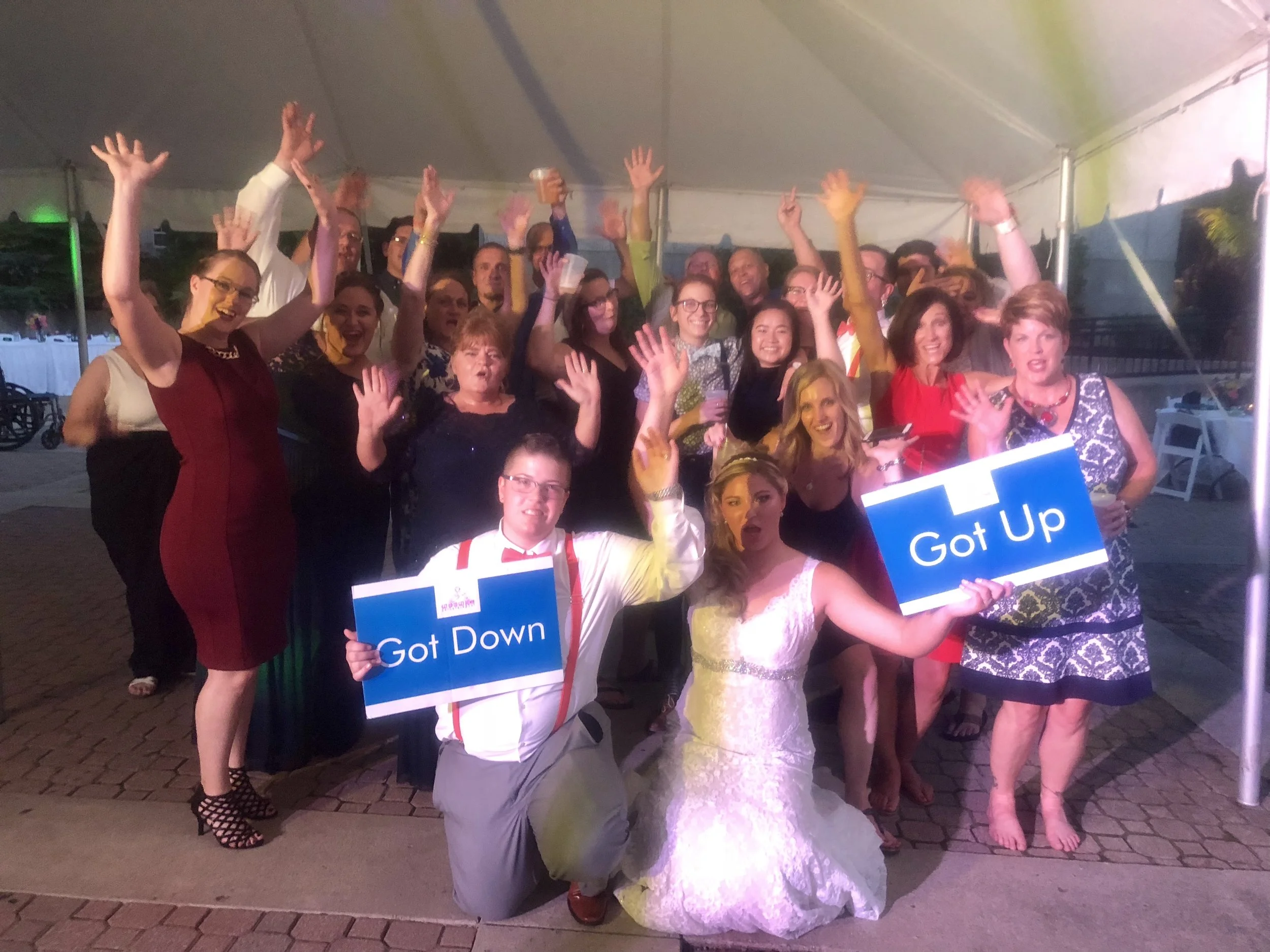 Bride, groom, and guests cheering beneath a reception tent at the Botanical Gardens.