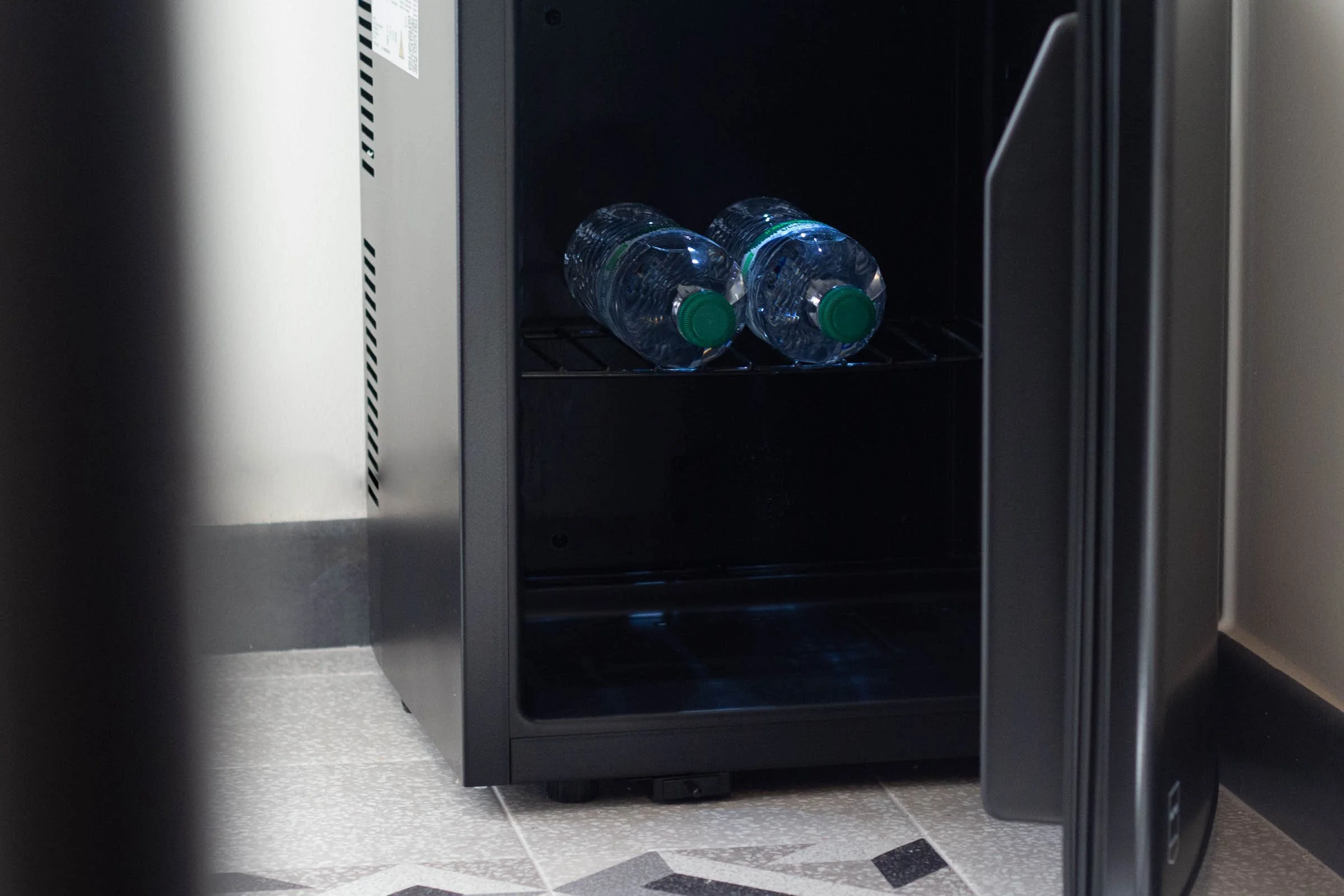 Due bottiglie di plastica riempite con acqua vengono inserite in una macchina per la refrigerazione o il freezer.