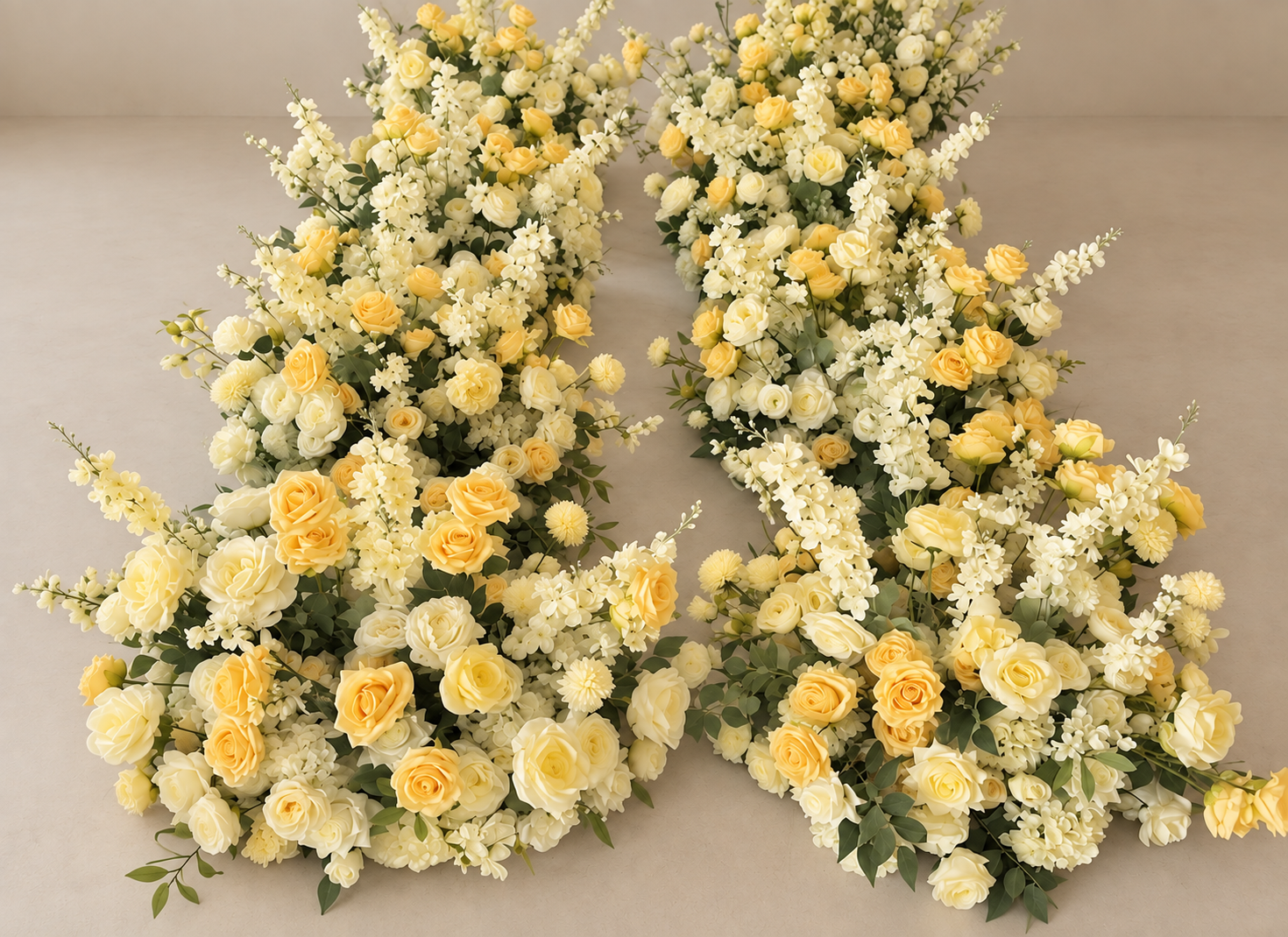 Several floral arrangements made of cream and yellow roses, white snapdragons, and other white flowers with green foliage, laid on a flat surface.