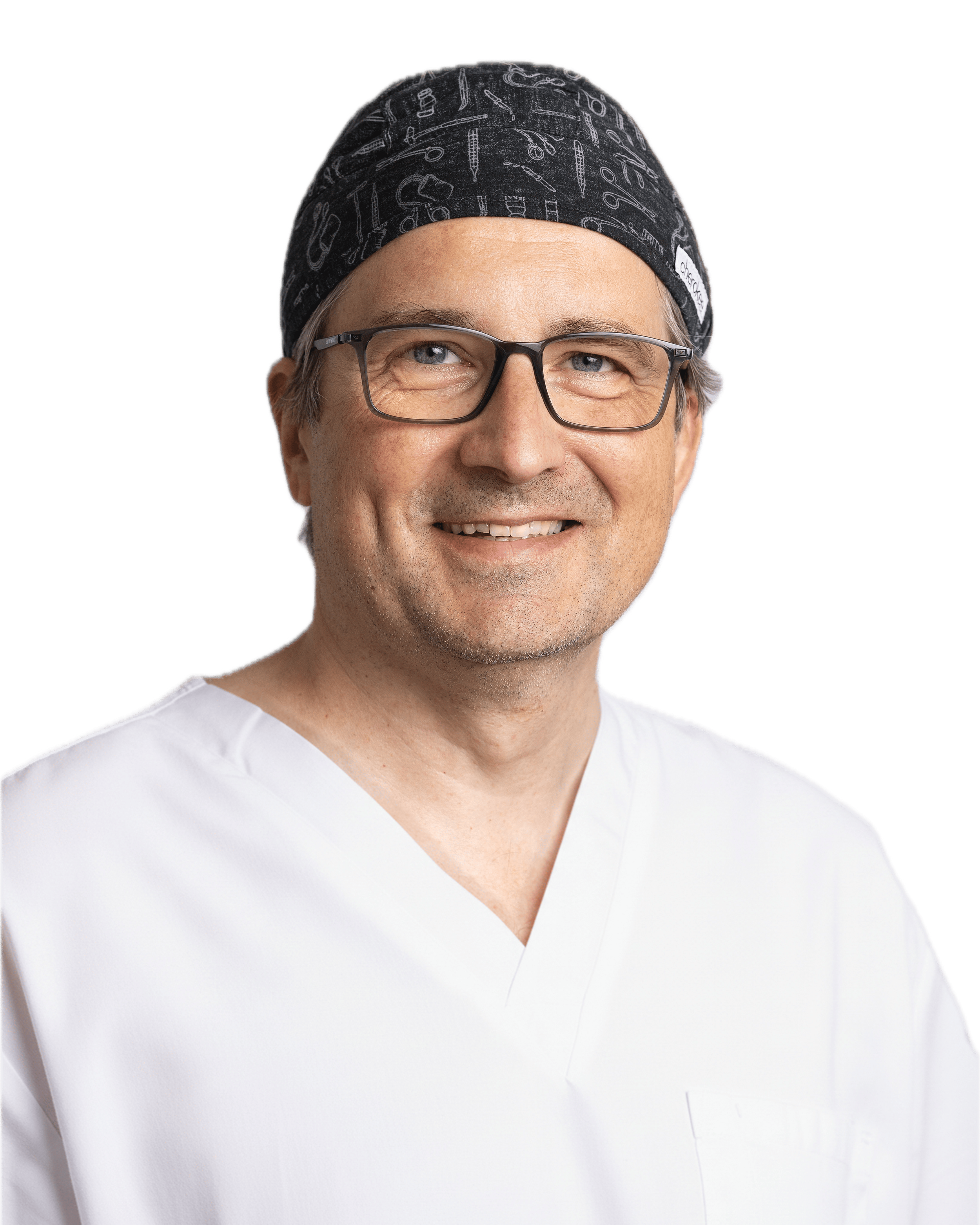 Oberkörper eines Mannes in weißem Arztkittel, mit Brille, Lächeln, trägt schwarzen OP-Kapu mit medizinischen Symbolen.
